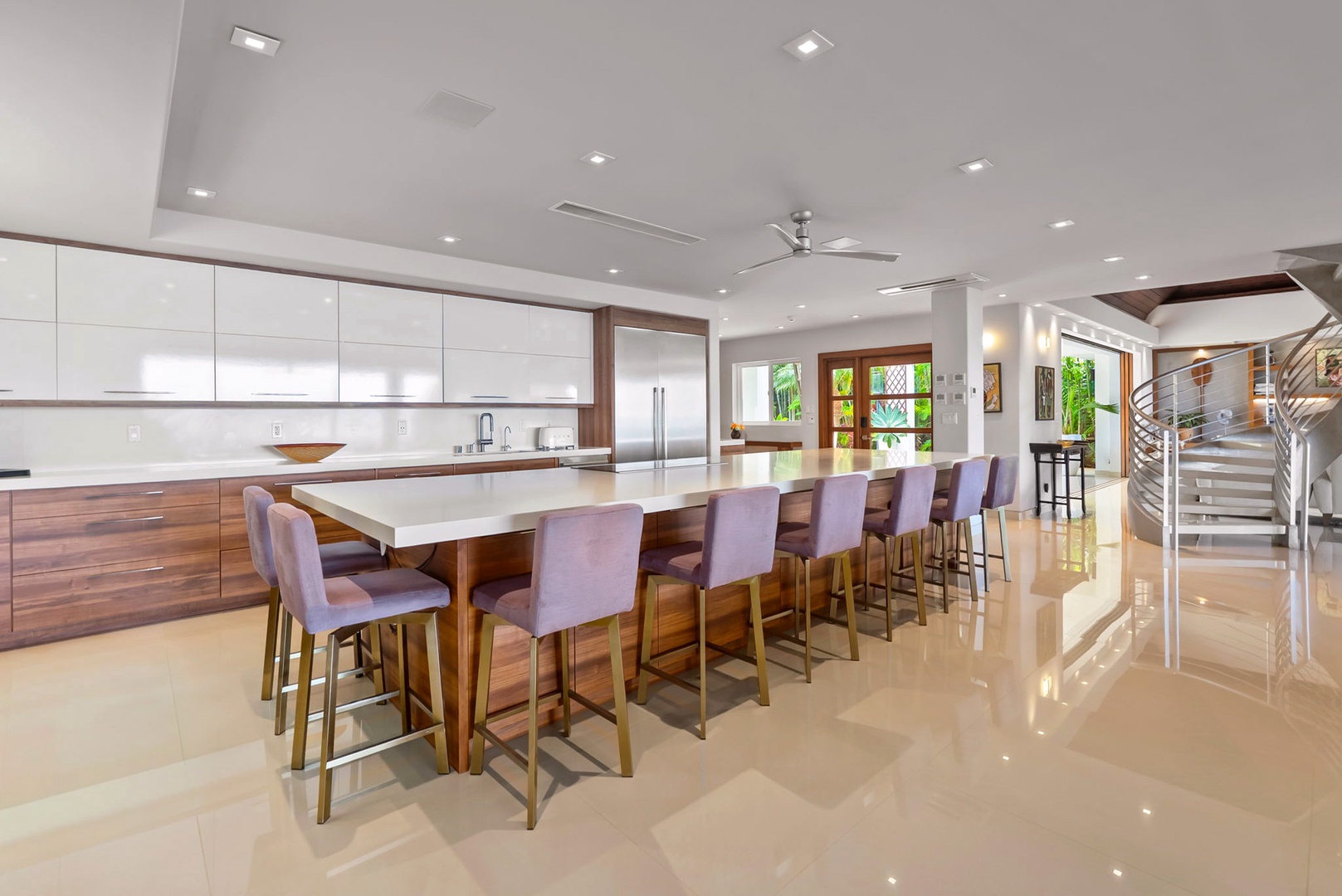 Honolulu Vacation Rentals, Diamond Head Beachfront Estate - Gather around this stunning kitchen island where sleek modern design meets warm wood tones. With seating for ten, you'll create unforgettable meals and memories in this chef-inspired space.
