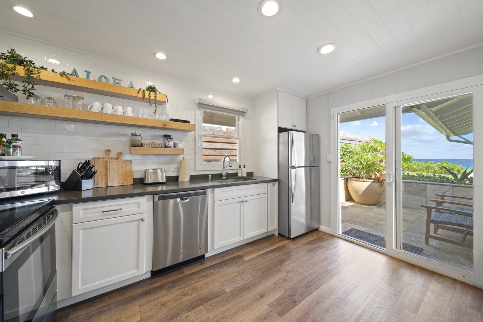 Haleiwa Vacation Rentals, Hale Nalu - The first kitchen has lots of natural light thanks to the sliding glass doors opening to the backyard