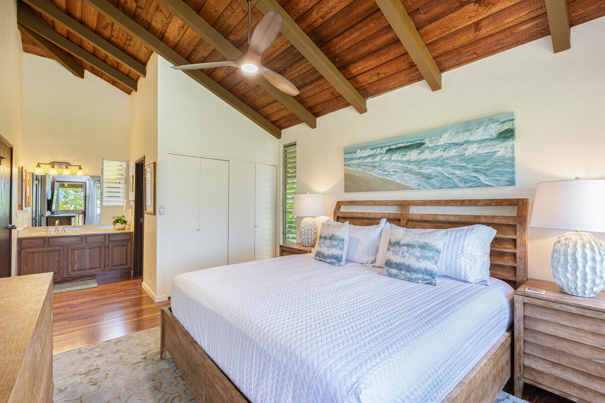 Princeville Vacation Rentals, Hale Ohana Ho'omaka - Primary suite with king bed, high ceilings, and warm wood tones. Includes a private ensuite bathroom.