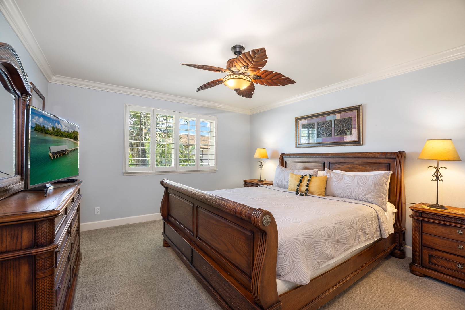 Rest in this elegant bedroom with rich wood furnishings, soft lighting, and garden views through bright windows.