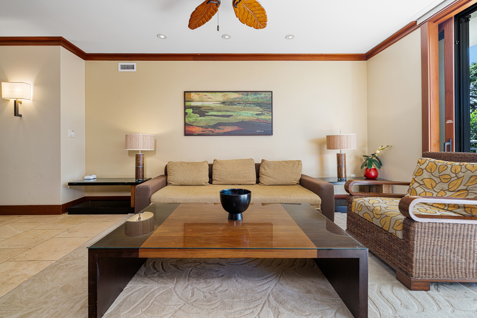 Relax in this spacious living area featuring comfortable seating, warm tropical touches, and natural light streaming through open doors—your perfect retreat after a day of adventure.