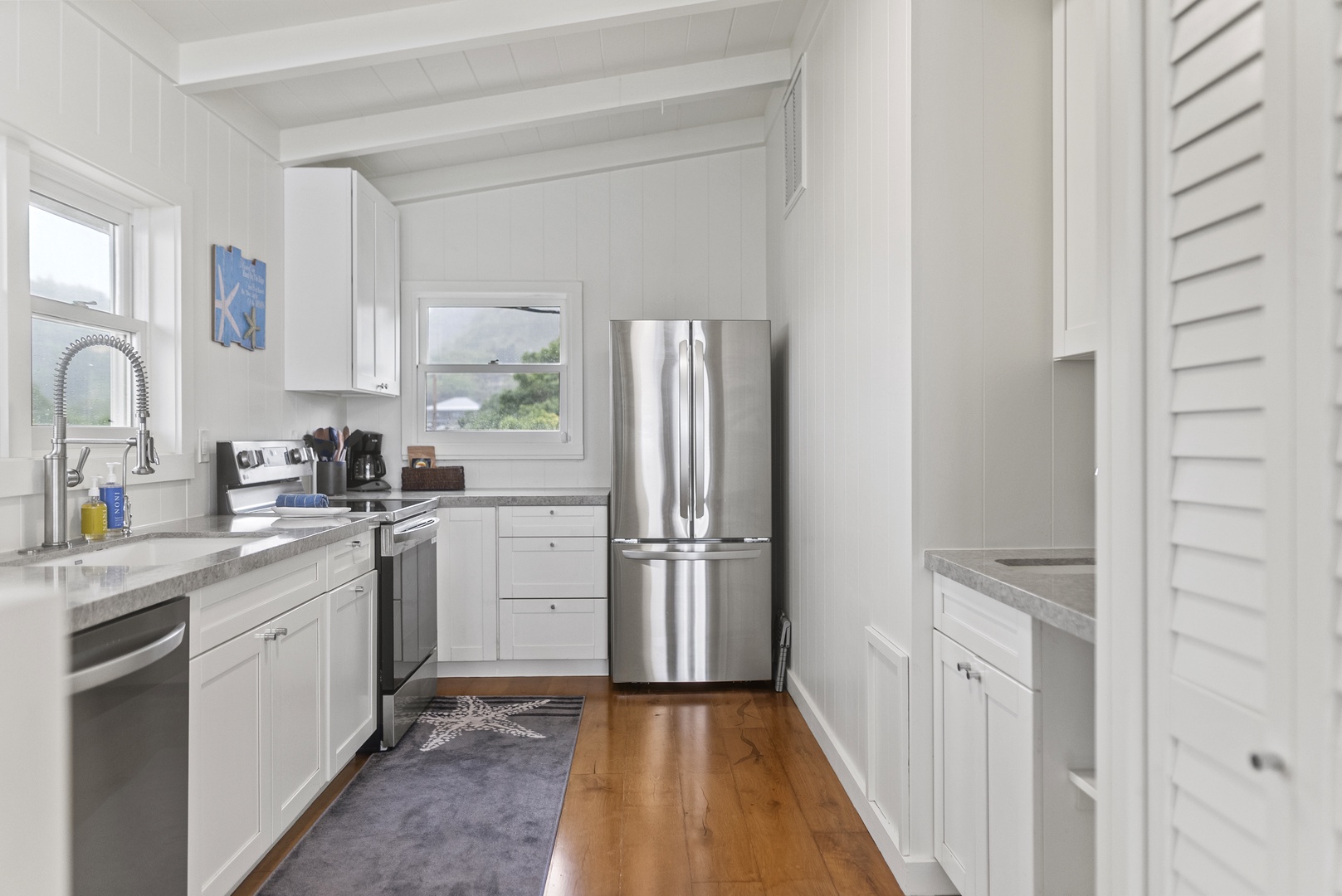 Haleiwa Vacation Rentals, Surfer's Paradise - Bright galley kitchen with sleek stainless steel appliances, perfect for preparing fresh island meals before heading to the beach.