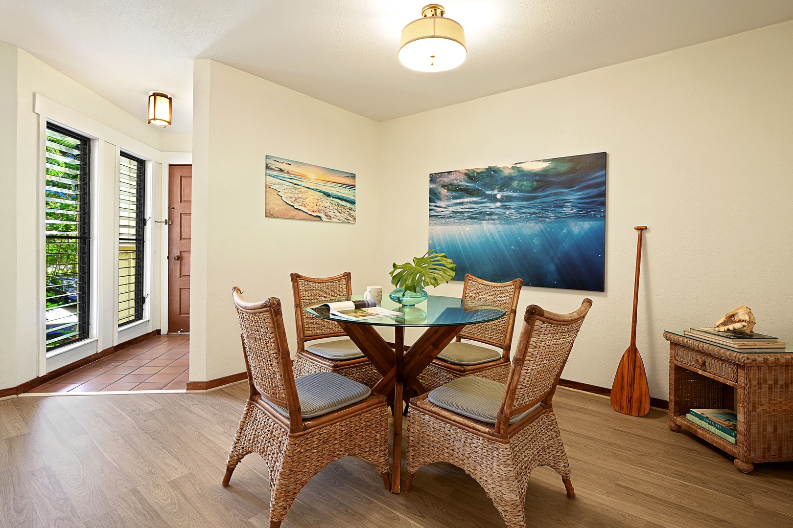 Koloa Vacation Rentals, Waikomo Streams 121 - The dining nook is set up almost like an art gallery, where from the glass table set for four, you can view the artwork showcasing the beauty of Hawai’i