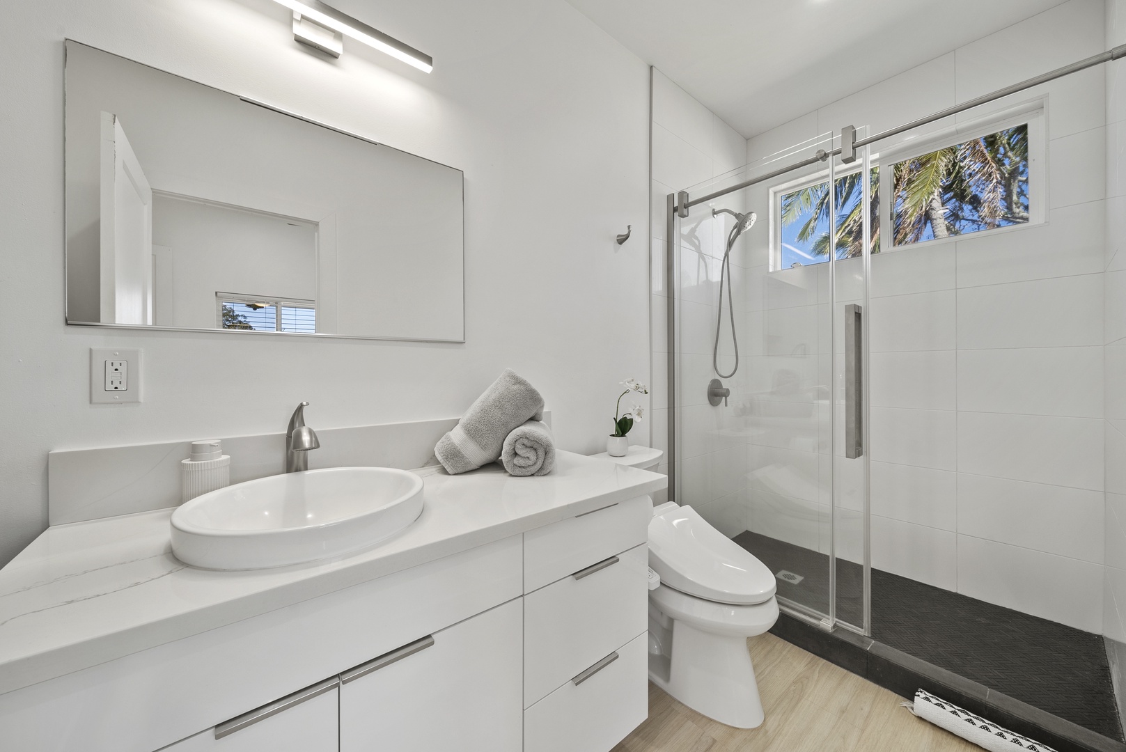 Haleiwa Vacation Rentals, Sunset Beach Island Retreat - Ensuite main bath features a glass-enclosed shower with modern fixtures and a window that lets in natural light