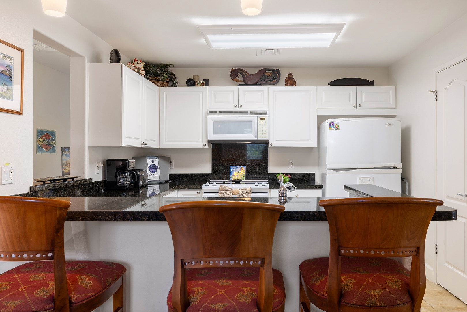 Kapolei Vacation Rentals, Ko Olina Kai 1105E - Your fully-equipped kitchen awaits with crisp white cabinetry, granite countertops, and a cozy breakfast bar. Whip up your favorite meals in this bright, functional space.