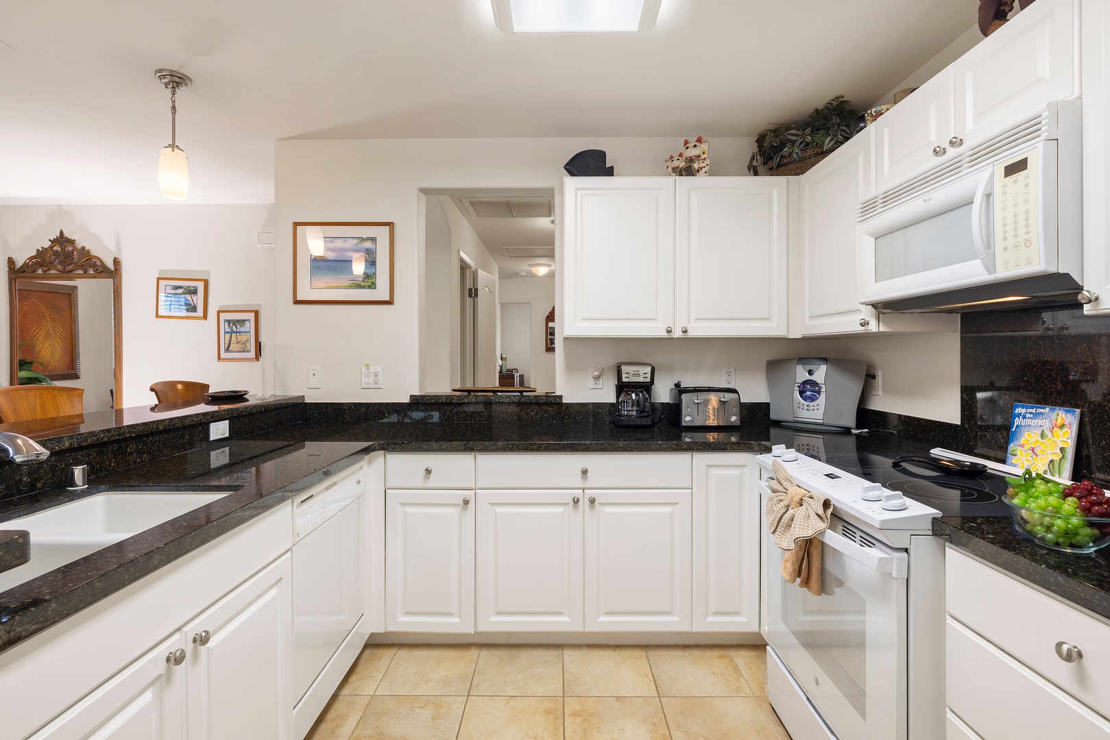 Kapolei Vacation Rentals, Ko Olina Kai 1105E - Step into your fully equipped kitchen with dark granite counters and bright white cabinetry—everything you need to prepare delicious home-cooked meals during your stay.