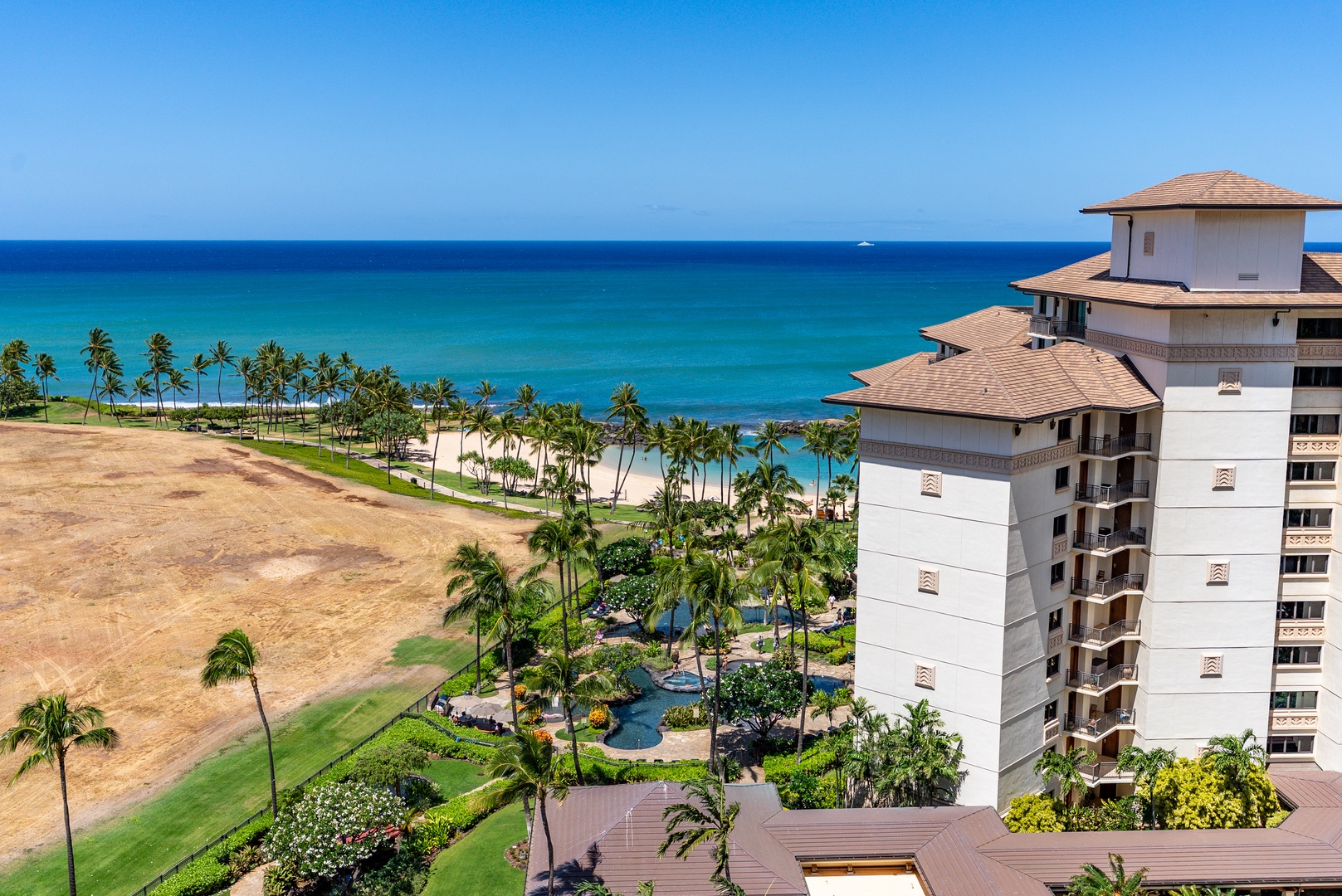 Kapolei Vacation Rentals, Ko Olina Beach Villas O1404 - Green paths, a resort tower, and the ocean stacking up beyond from the fourteenth floor.
