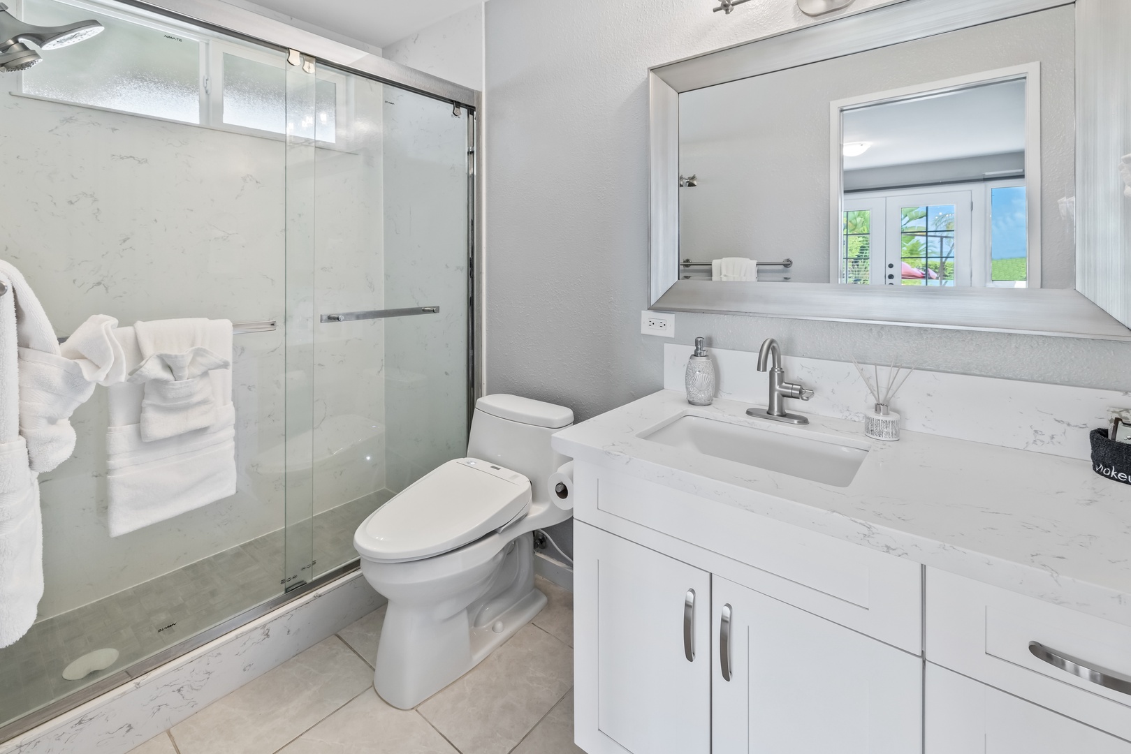 Honolulu Vacation Rentals, Nanea Kai Villa - Bright and modern shared bathroom with a glass shower and sleek vanity.