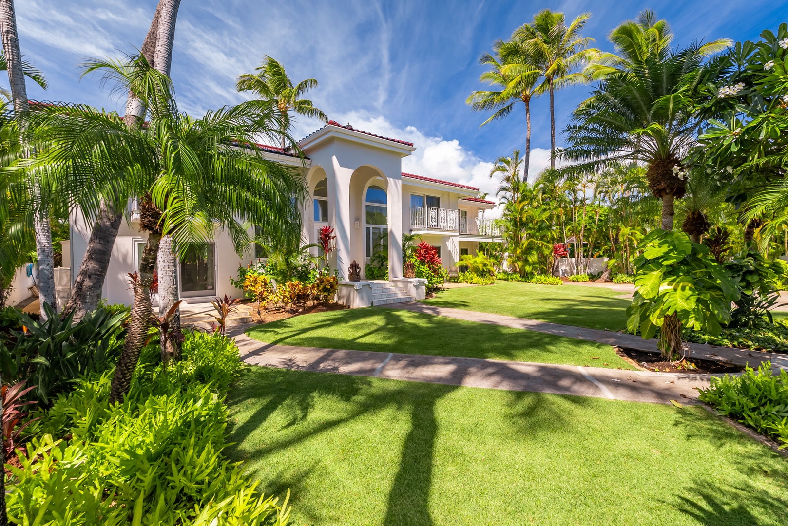 Honolulu Vacation Rentals, Kahala Oasis - Front view of the villa, surrounded by lush lawn and tropical landscaping, offering a warm island welcome.