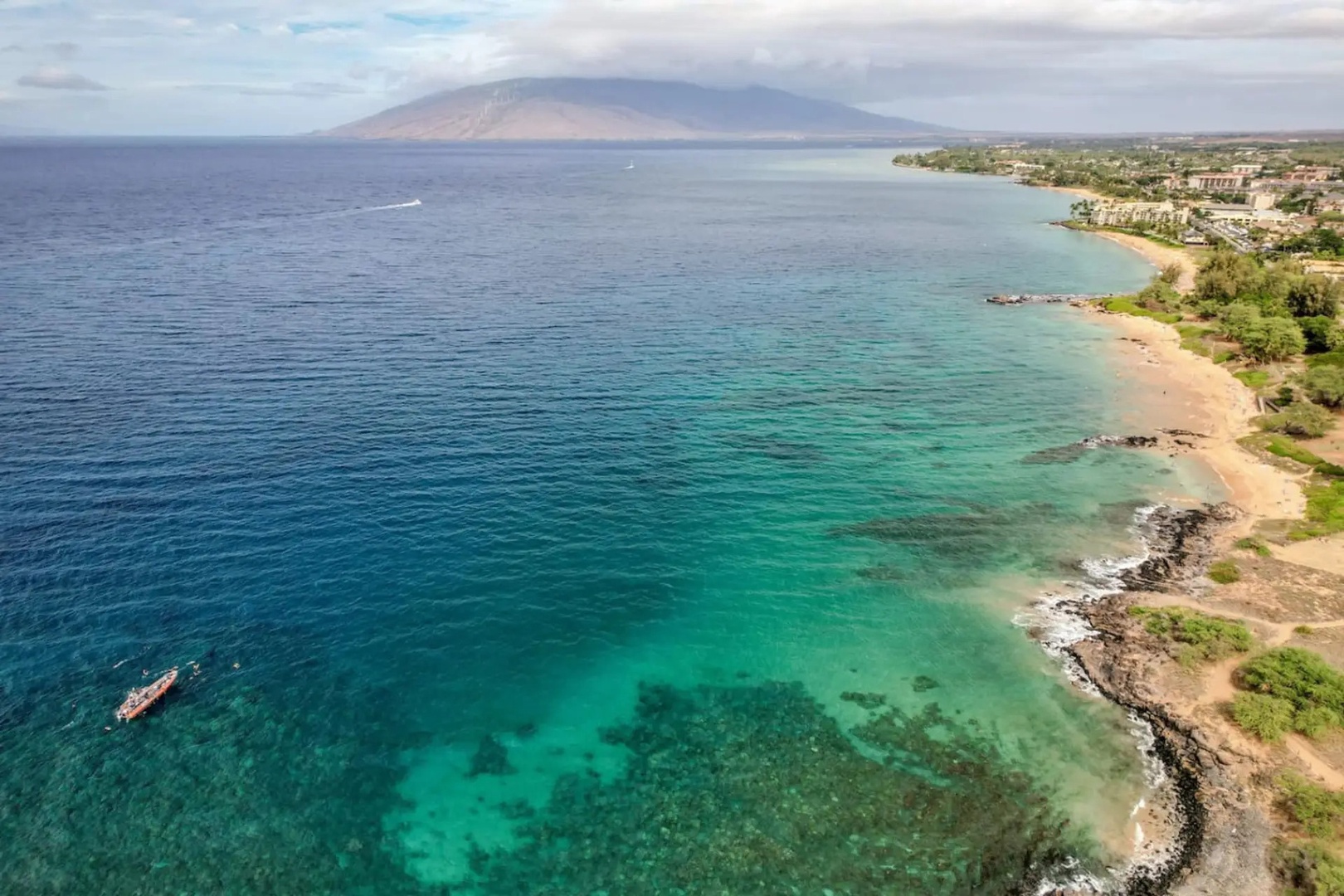 Kihei Vacation Rentals, Maui Kamaole E103 - From above, the coastline stretches toward the West Maui mountains rising across the channel.