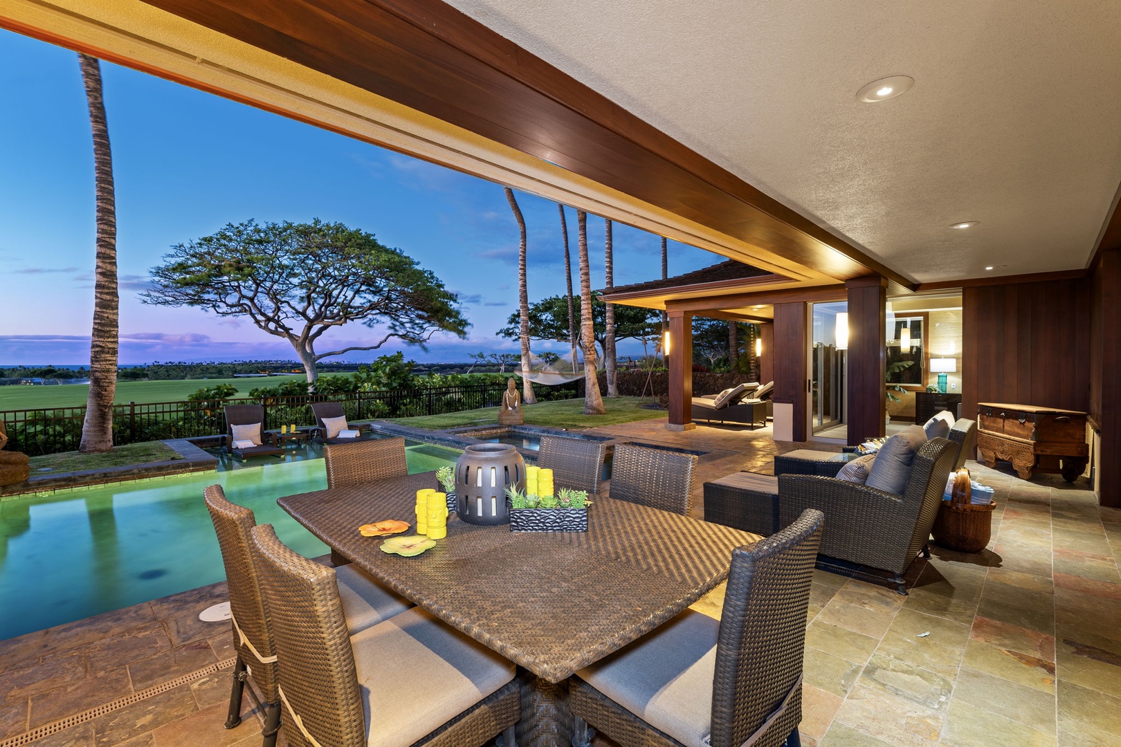 Kailua Kona Vacation Rentals, 3BD Pakui Street Estate (149) at Hualalai Resort - A lit table, a glowing pool, and the sky still burning off the day behind them.