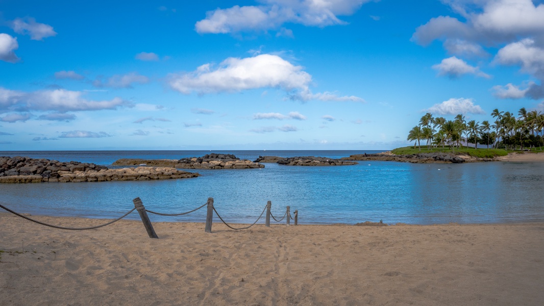 A tranquil lagoon with volcanic rock formations and swaying palms.