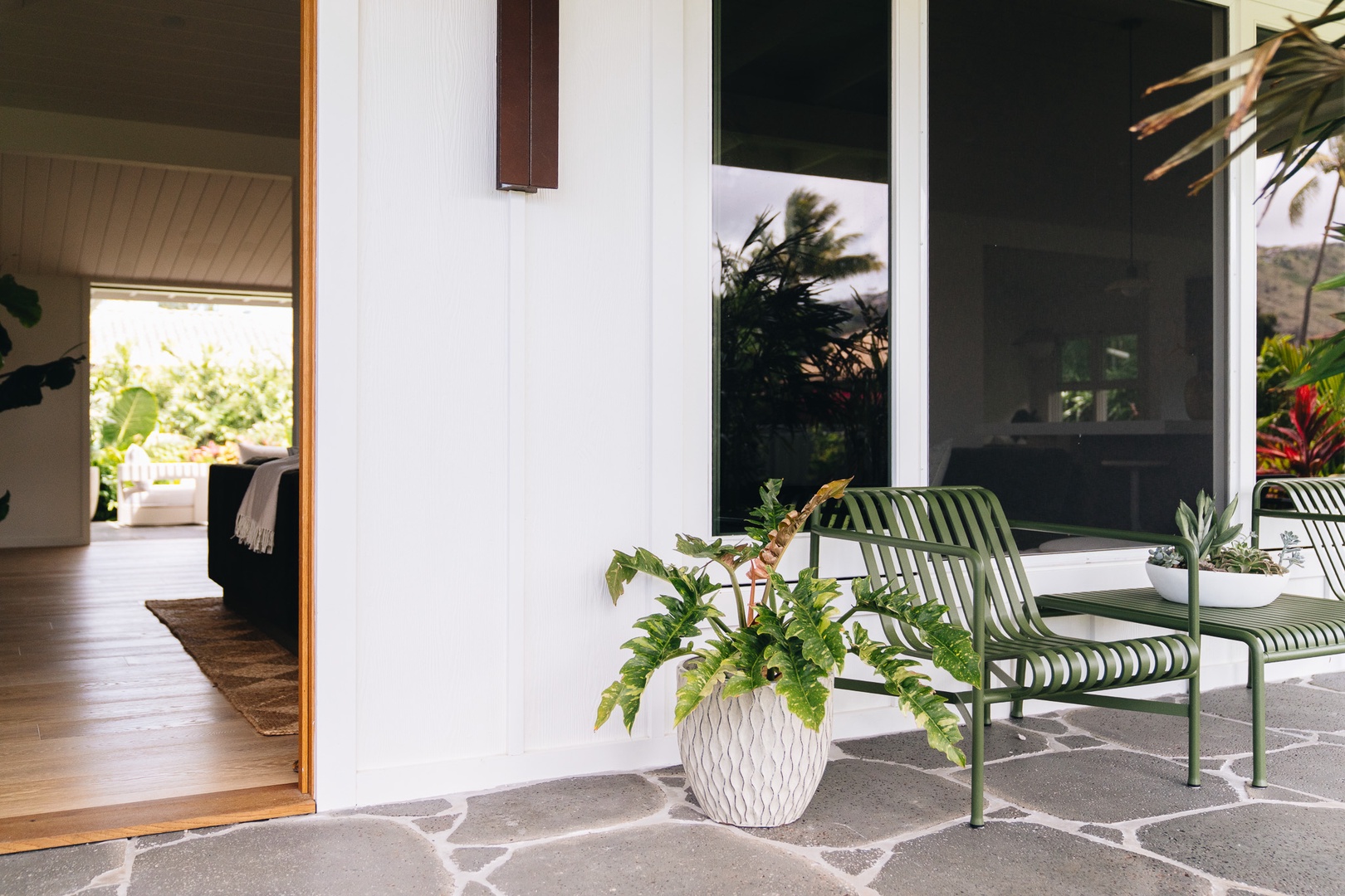 Honolulu Vacation Rentals, Surfside Bungalow** - A welcoming outdoor seating area framed by lush landscaping and island-inspired design.