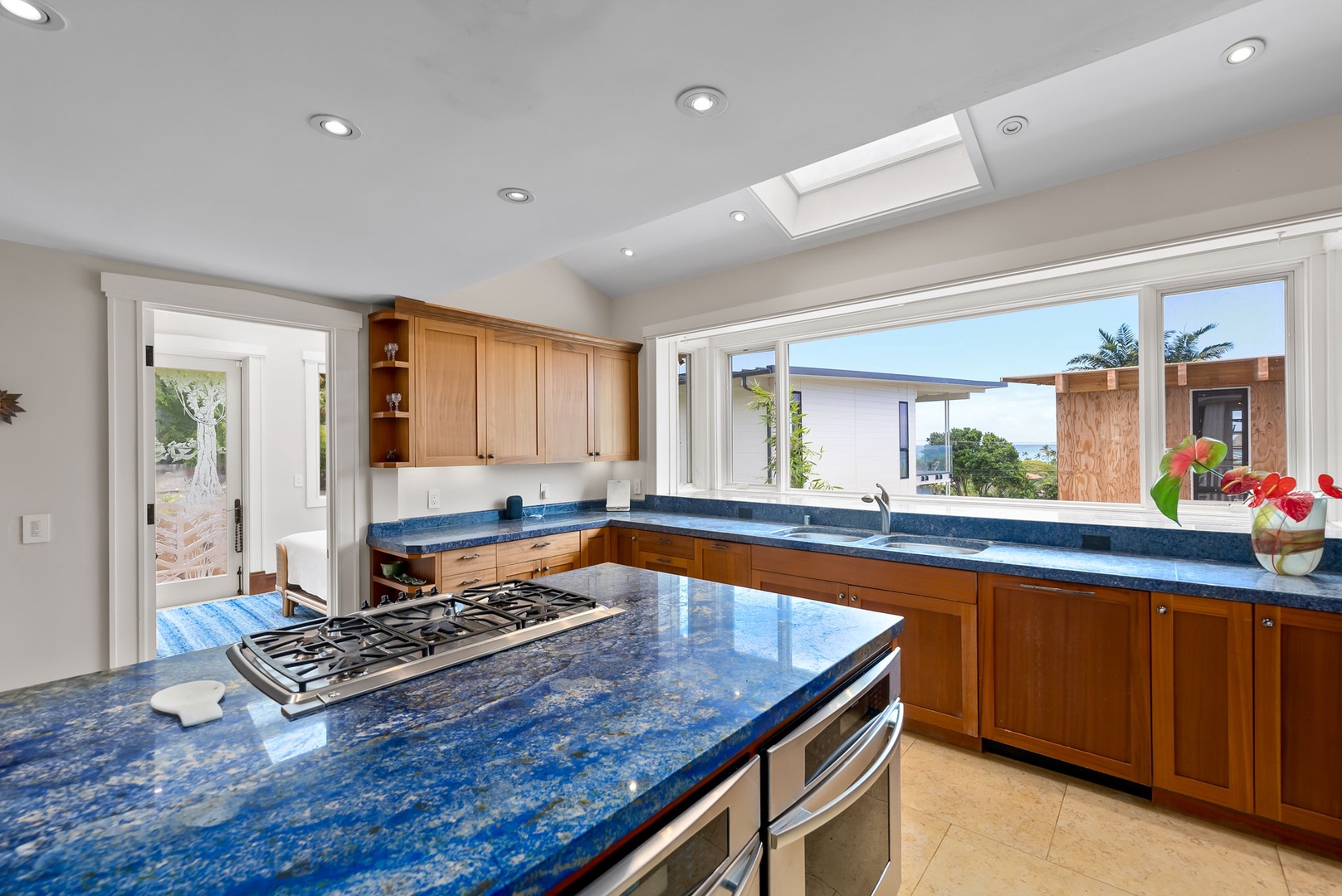 Kailua Vacation Rentals, Leaf House - Imagine creating your dream meals in this sunlit kitchen with sparkling blue granite countertops, spacious island, and stunning tropical views through expansive windows that invite the outdoors in.