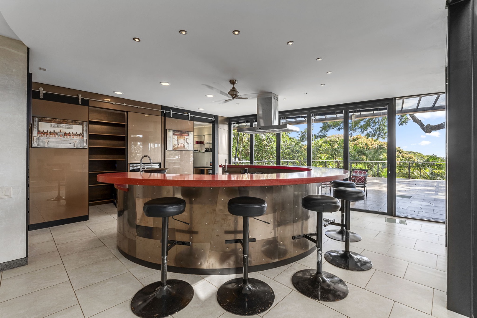 Honolulu Vacation Rentals, Tantalus Glass House (3 BD) - Modern kitchen features a stunning curved island with bar seating, perfect for morning coffee or evening cocktails while enjoying garden views.
