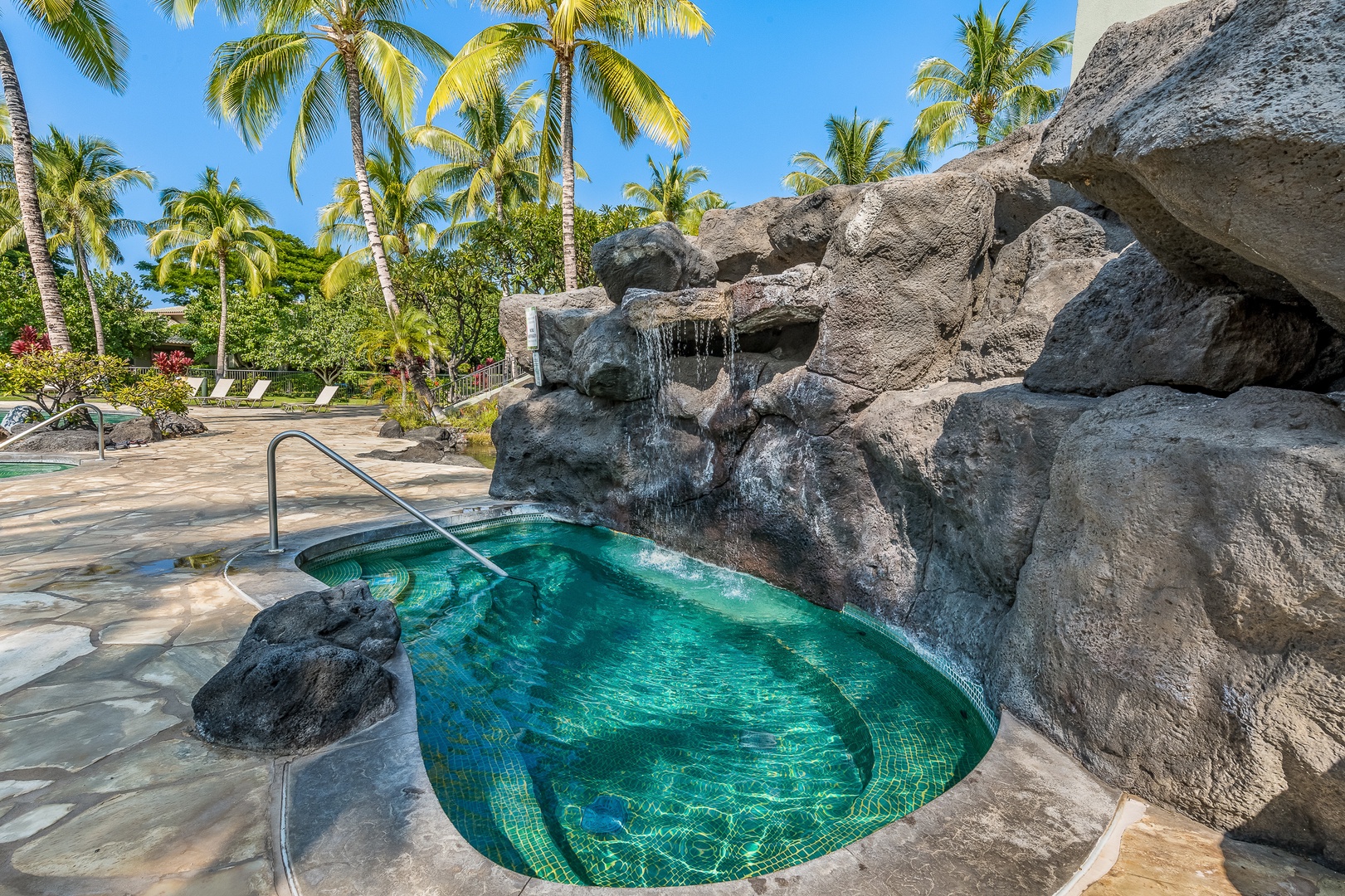 Kamuela Vacation Rentals, Mauna Lani Fairways #204 - Soak in the rejuvenating hot tub surrounded by lava rock and a cascading waterfall—Hawaiian serenity at its finest.