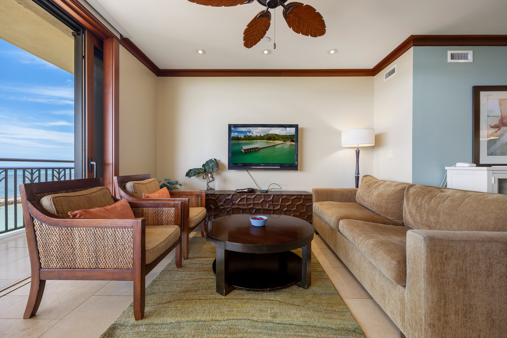Kapolei Vacation Rentals, Ko Olina Beach Villas B609 - Relax in your elegant living room with plush seating, tropical ceiling fan, and stunning ocean views through floor-to-ceiling windows.