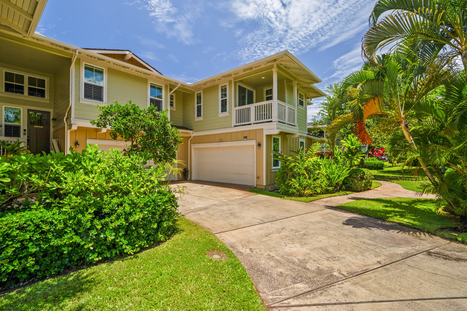 Princeville Vacation Rentals, Kaimana Villa - Modern two-story vacation home with covered garage and tropical landscaping in a peaceful residential setting.