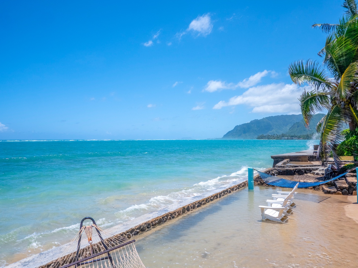 Hauula Vacation Rentals, Private Beach Paradise - Pristine beachfront with turquoise waters, mountain backdrop, and tropical palm trees creating the perfect island getaway setting.