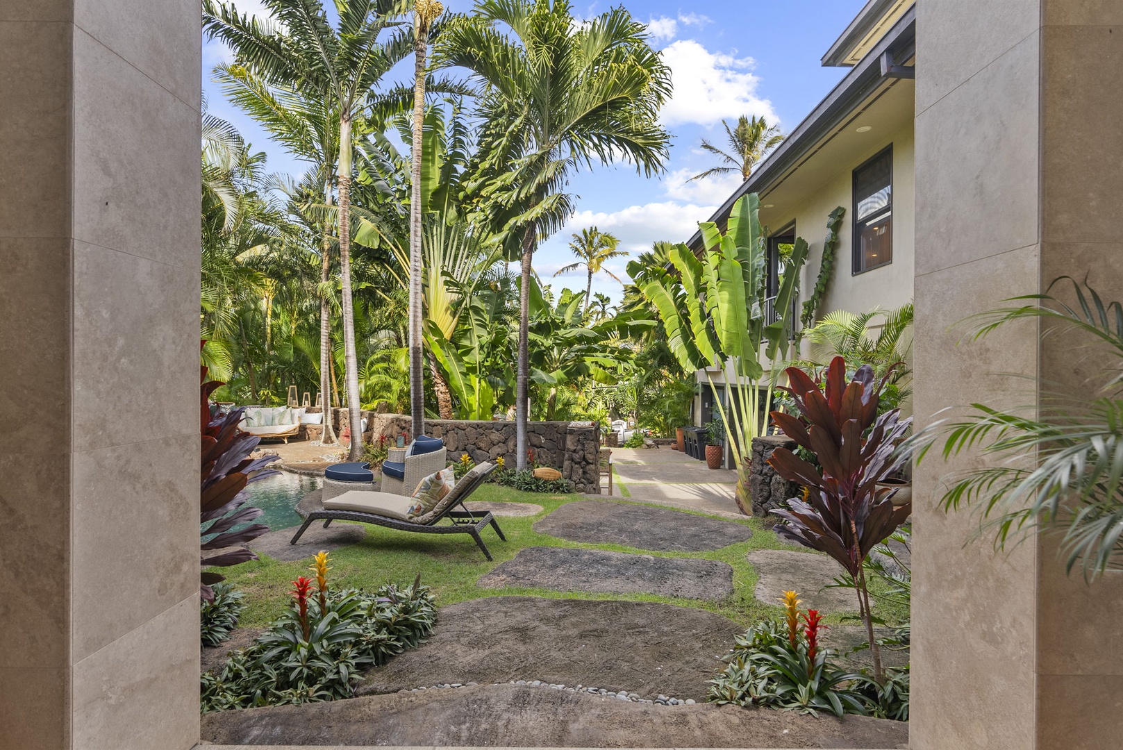 Honolulu Vacation Rentals, Pili Pono - Poolside area with lounge chairs and tropical gardens.