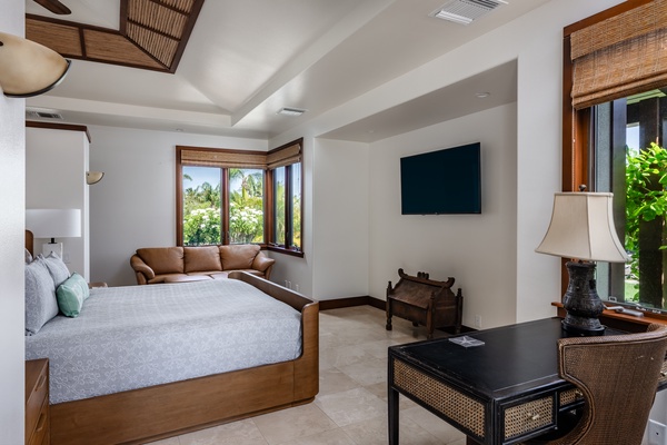 Kamuela Vacation Rentals, Canoe House & Beach Walker at Champion Ridge - Comfortable bedroom with a large bed, sitting area, and wall-mounted TV, offering a cozy space to relax and unwind.
