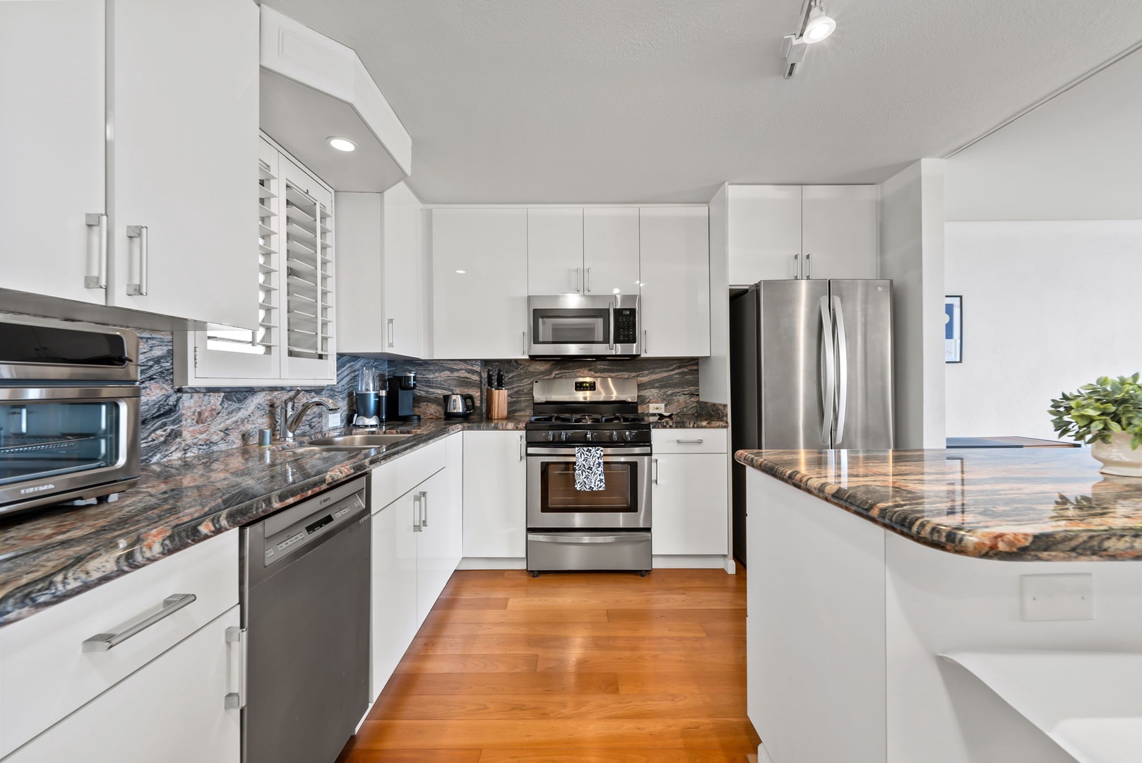 Honolulu Vacation Rentals, Colony Surf Retreat - A modern kitchen with warm wood cabinetry and sleek finishes—perfect for everything from morning coffee to island-inspired dinners.