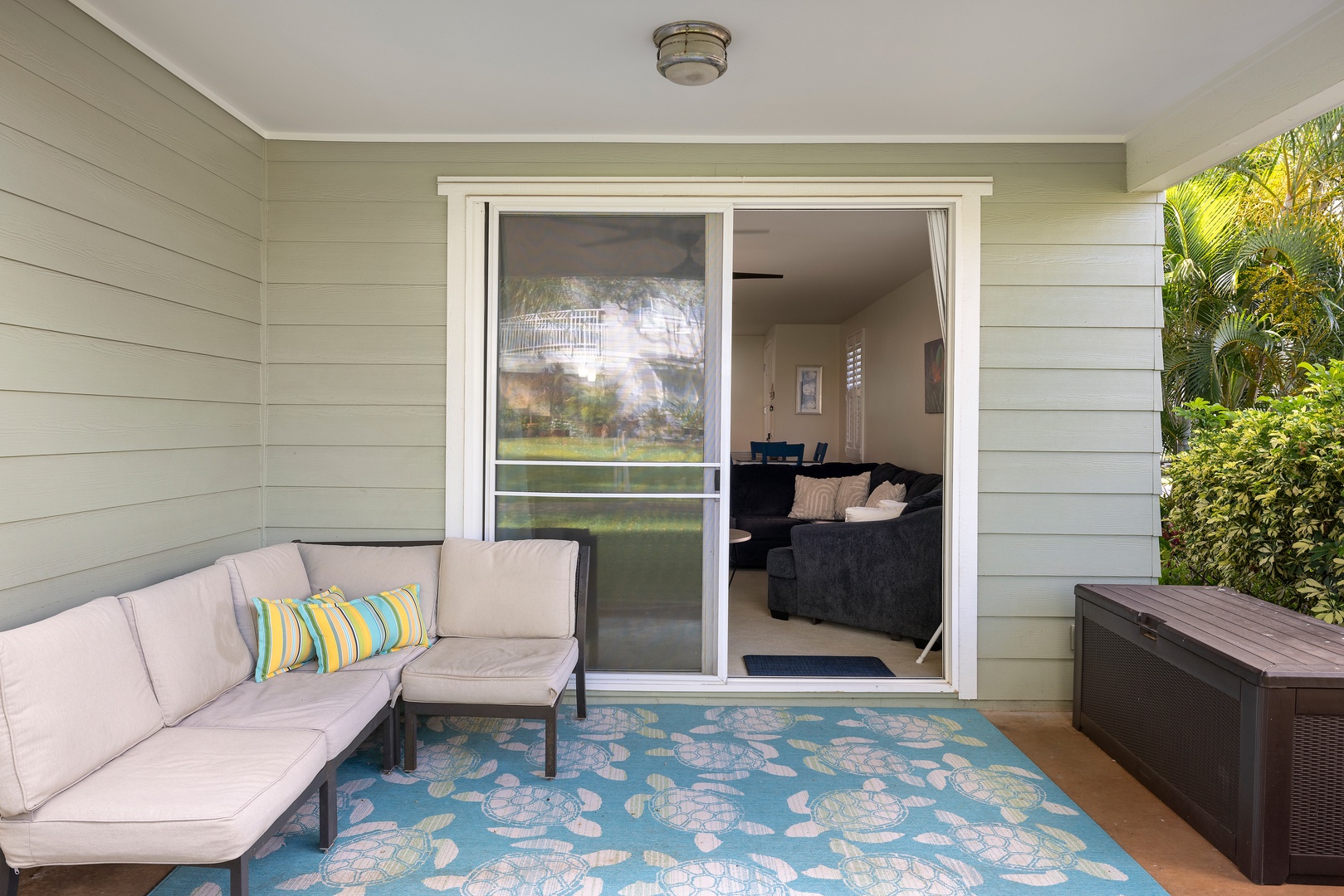 Step onto your private covered lanai with cozy seating and peaceful garden views just outside the living room.