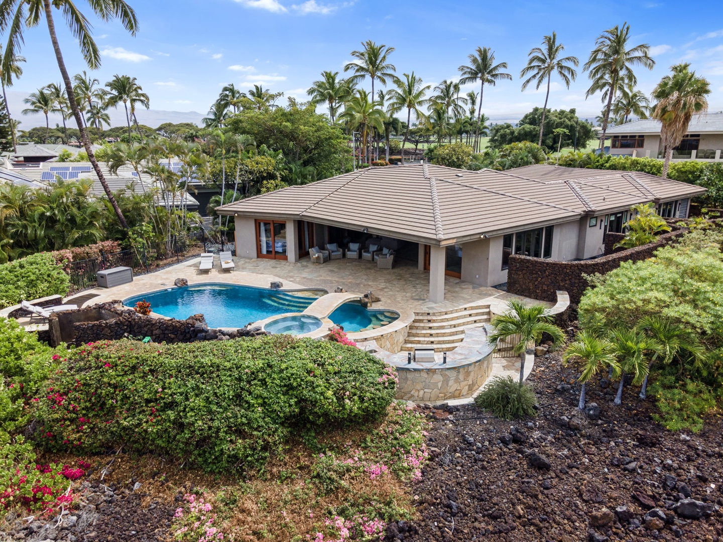 Kamuela Vacation Rentals, Hale Konane - A second angle of the pool and spa area, surrounded by palms and lava rock gardens.