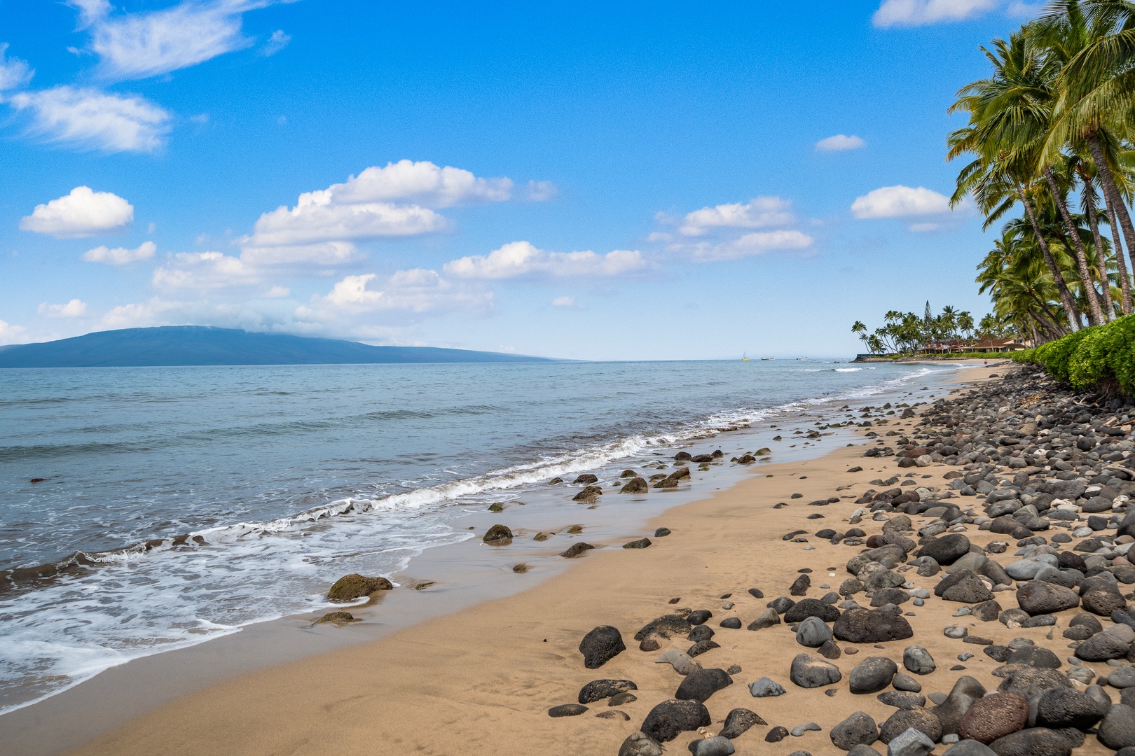 Lahaina Vacation Rentals, Puamana 254-2 - The beach at Puamana 254-2 is lined with black rocks, offering peaceful ocean views.
