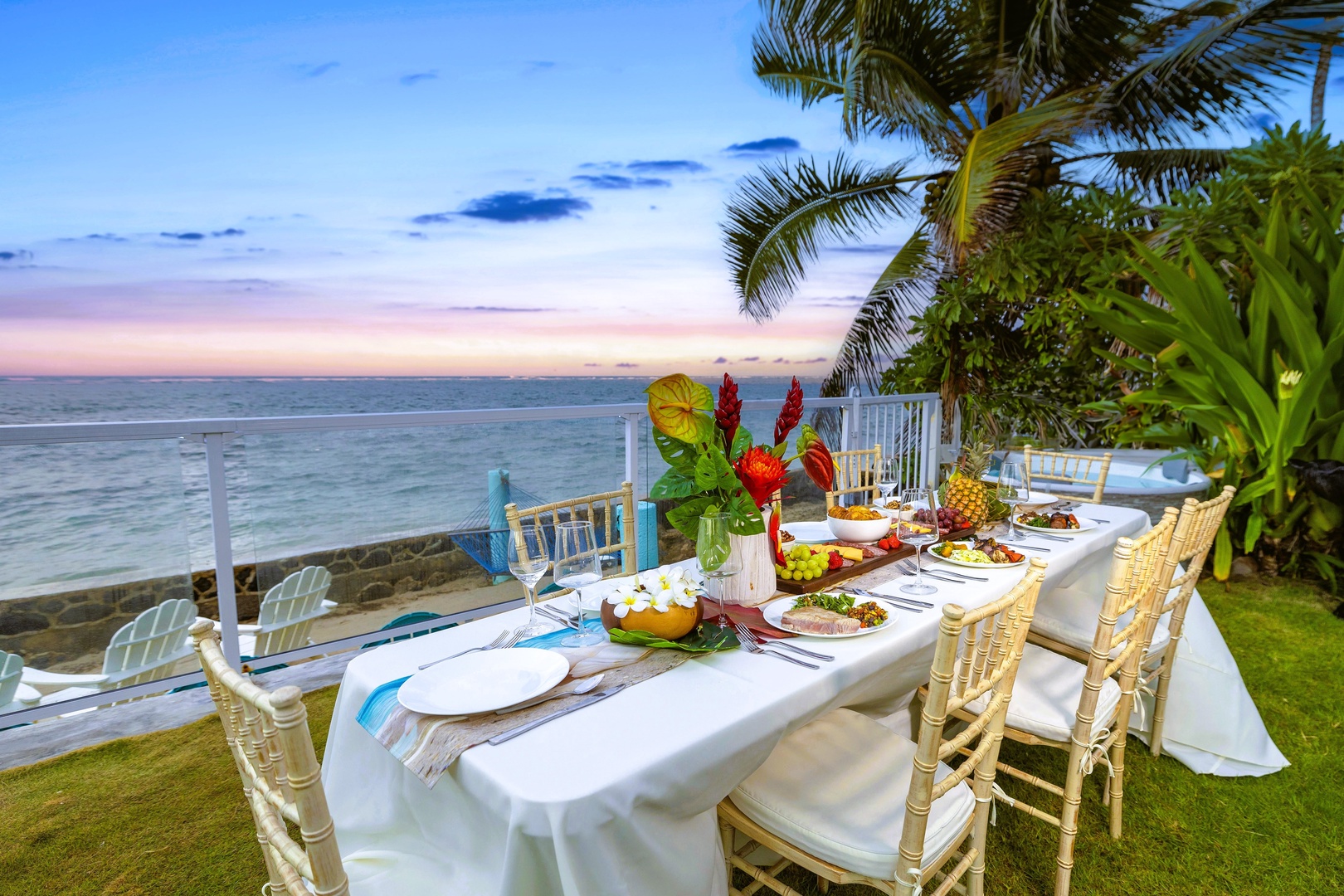 Hauula Vacation Rentals, Private Beach Paradise - A table set on the lawn as the light fades, dinner served oceanfront.
