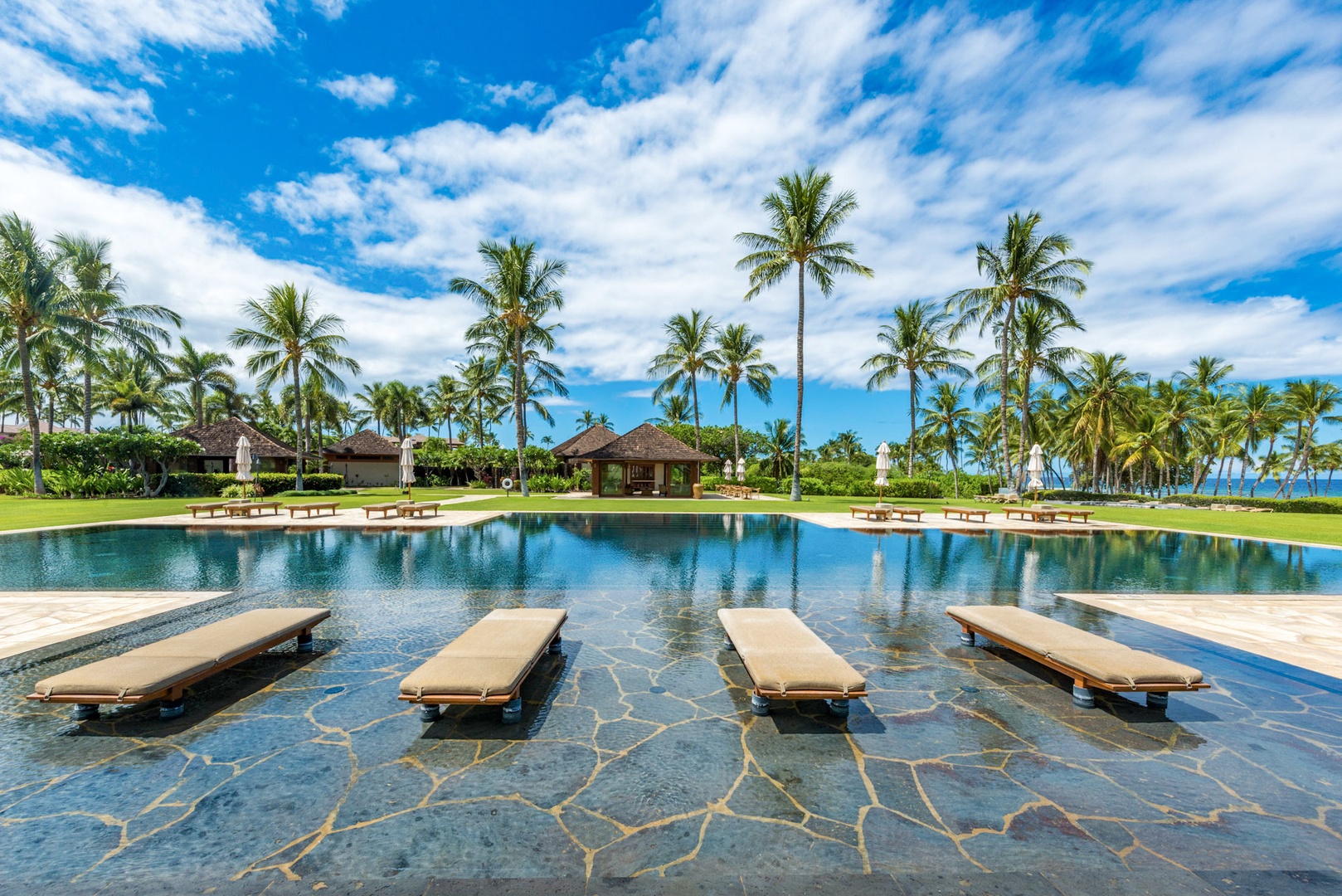 Kamuela Vacation Rentals, 3BD Na Hale 3 at Pauoa Beach Club at Mauna Lani Resort - 100-foot pool with loungers, coconut trees, and stunning views at Pauoa Beach Club