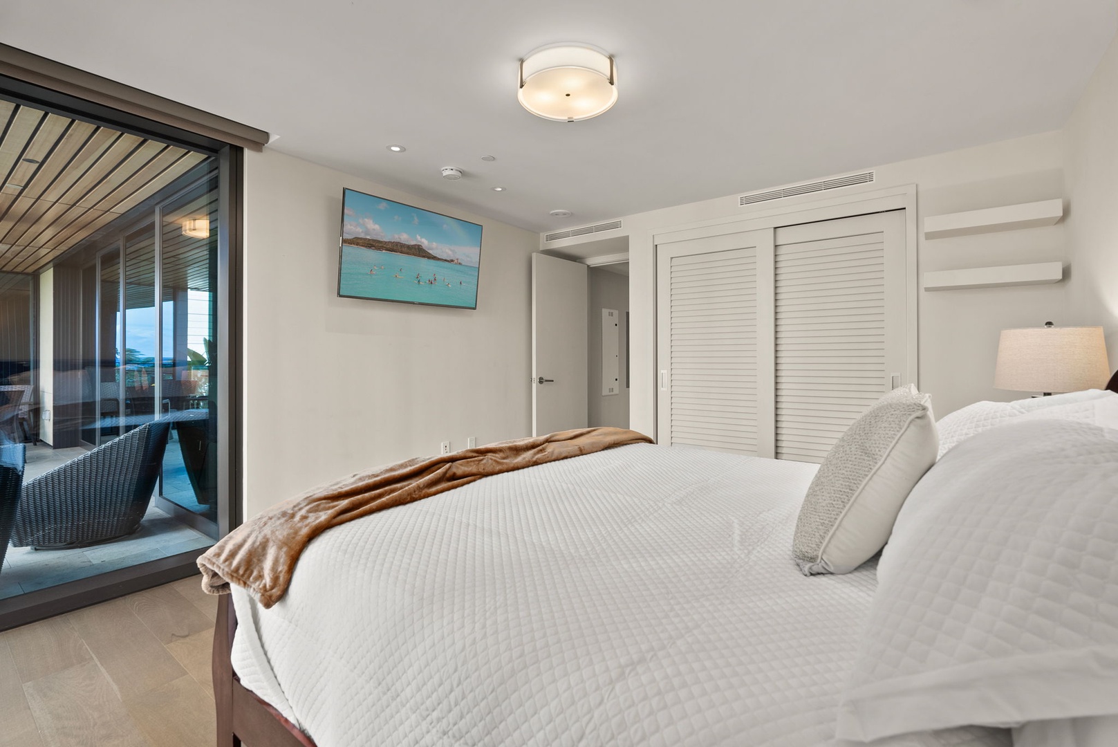 Honolulu Vacation Rentals, Park Lane Getaway - Elegant guest bedroom with a cozy bed, mounted TV, and spacious closet, offering comfort and convenience for a relaxing stay.