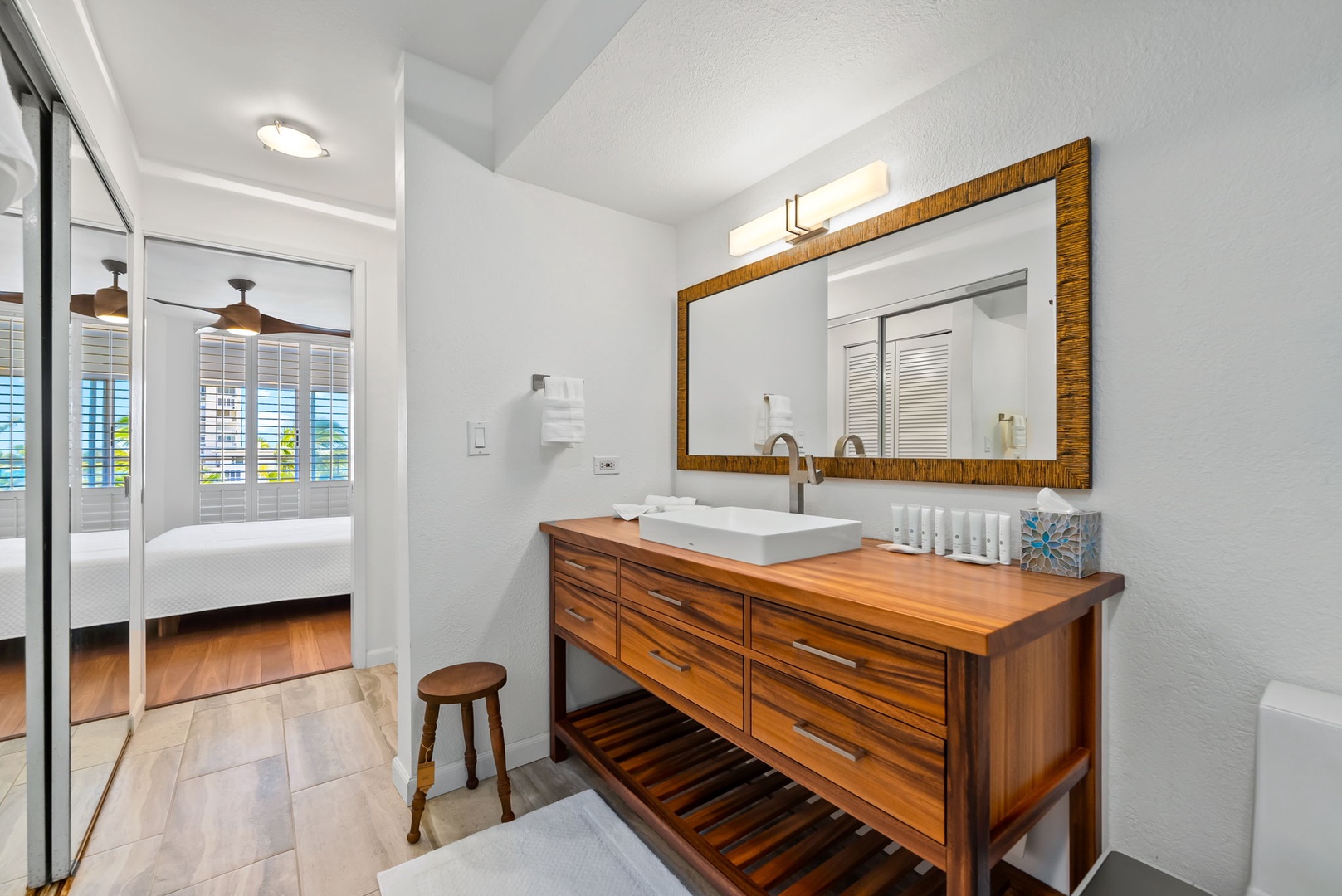 Honolulu Vacation Rentals, Colony Surf Retreat - Spa-like bathroom with rich wood cabinetry, ambient lighting, and natural finishes—perfect for post-beach refreshment.
