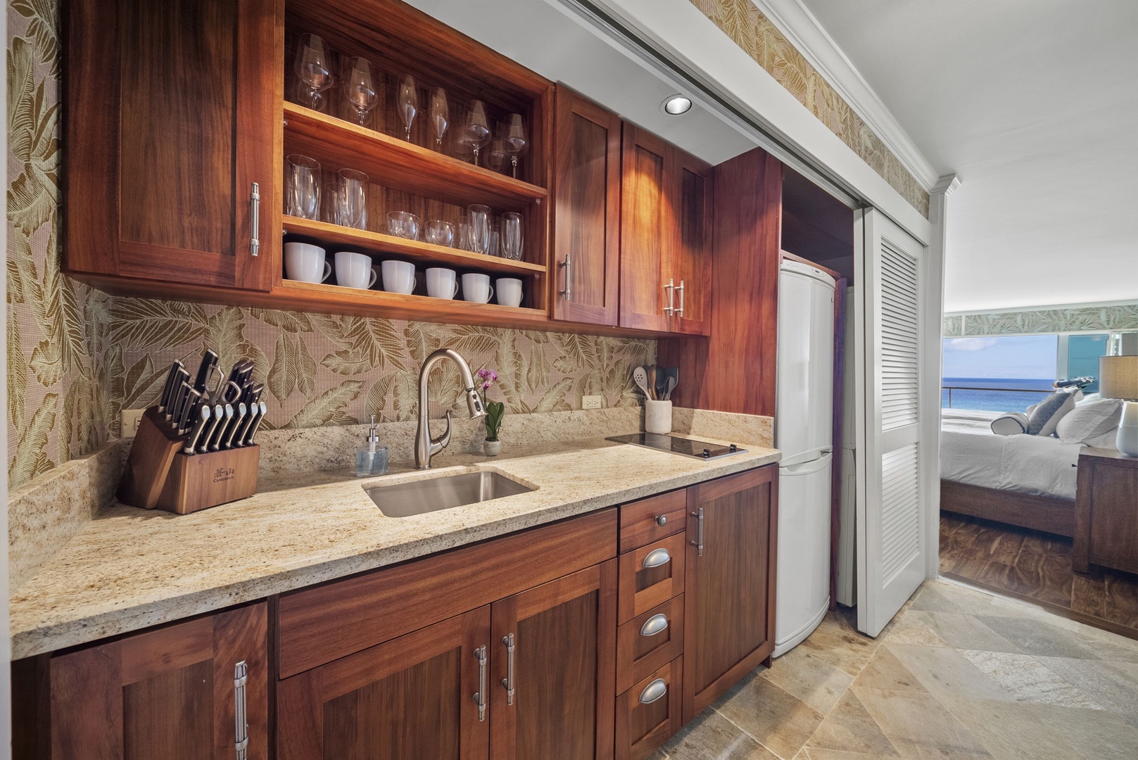 Honolulu Vacation Rentals, Colony Surf #1403 - Fully equipped kitchenette with elegant wood cabinets and granite countertops for easy meal prep.