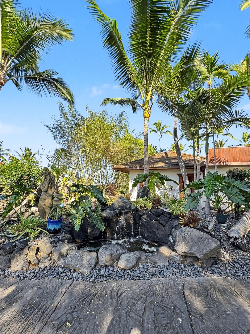 Kailua-Kona Vacation Rentals, Hahalua Bay Villa - Tropical landscaping with stone water feature beneath swaying palms creates a peaceful retreat.