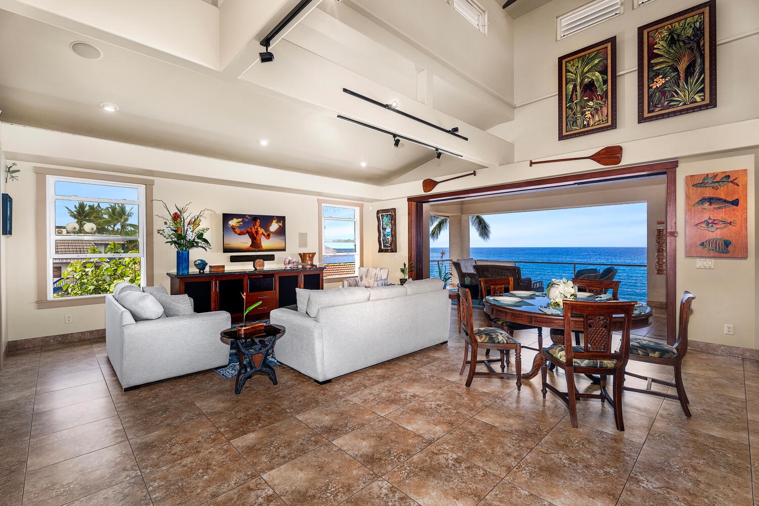 Kailua Kona Vacation Rentals, Kailani Vista - Sink into the living area’s comfy sofa or pull up a teak chair for cards—all while ocean breezes drift through the fully pocketed doors in the background.