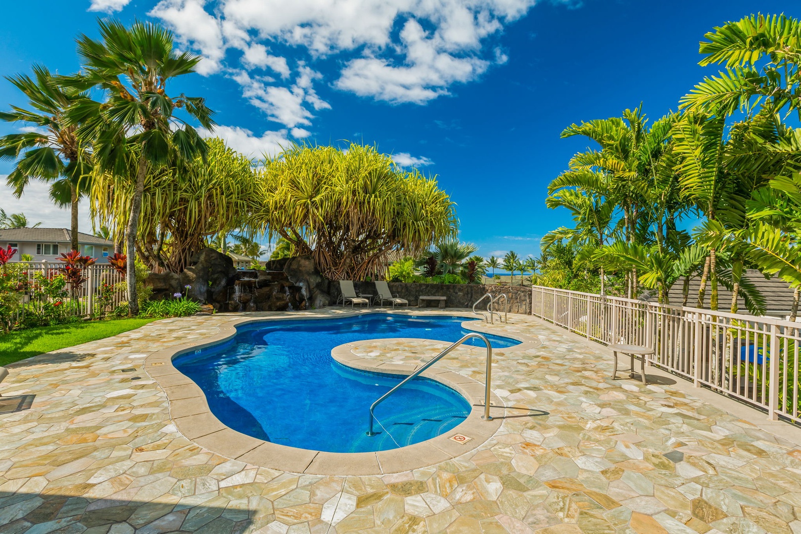 Princeville Vacation Rentals, Kaiulani #8 - Float in the curved pool, with a stone deck and tall palms all around.
