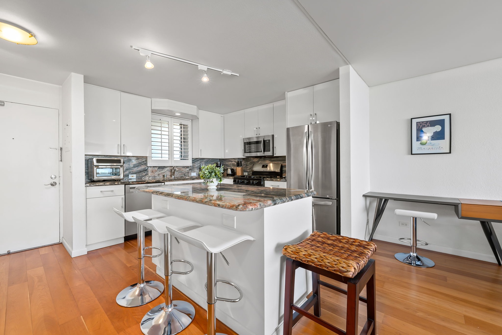 Honolulu Vacation Rentals, Colony Surf Retreat - Prepare meals with ease in a well-equipped kitchen featuring stone countertops, full-size appliances, and breakfast bar seating.