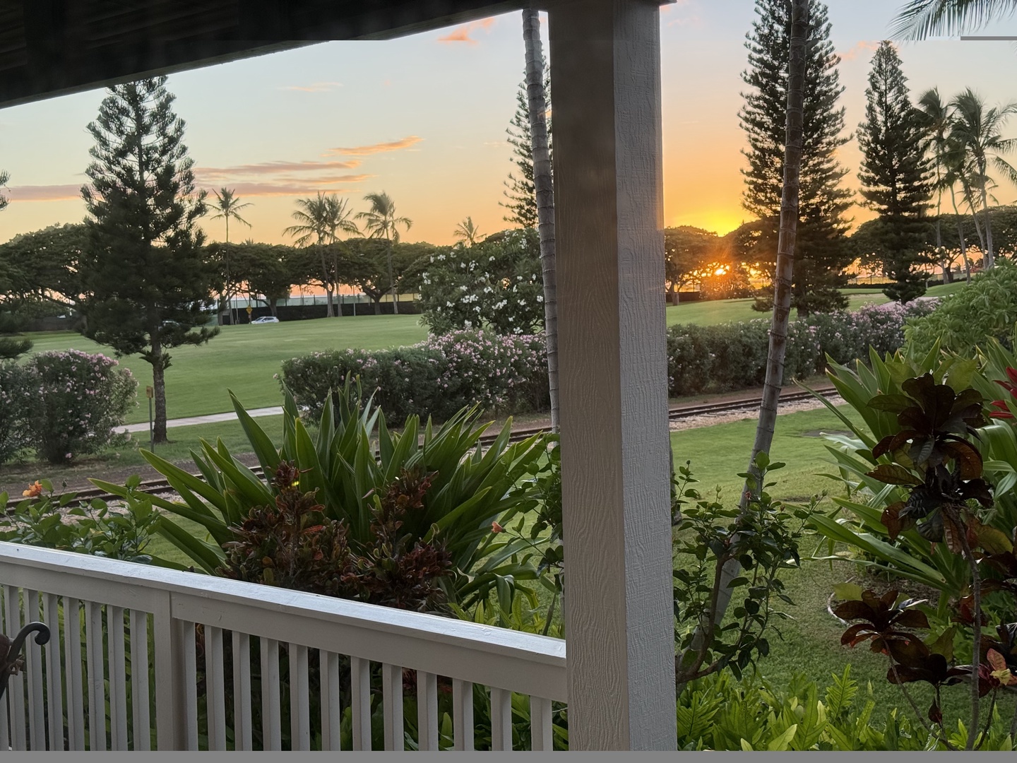 Kapolei Vacation Rentals, Coconut Plantation 1080-4 - Right as the sun touches the tree line, gold spills across the whole lanai.