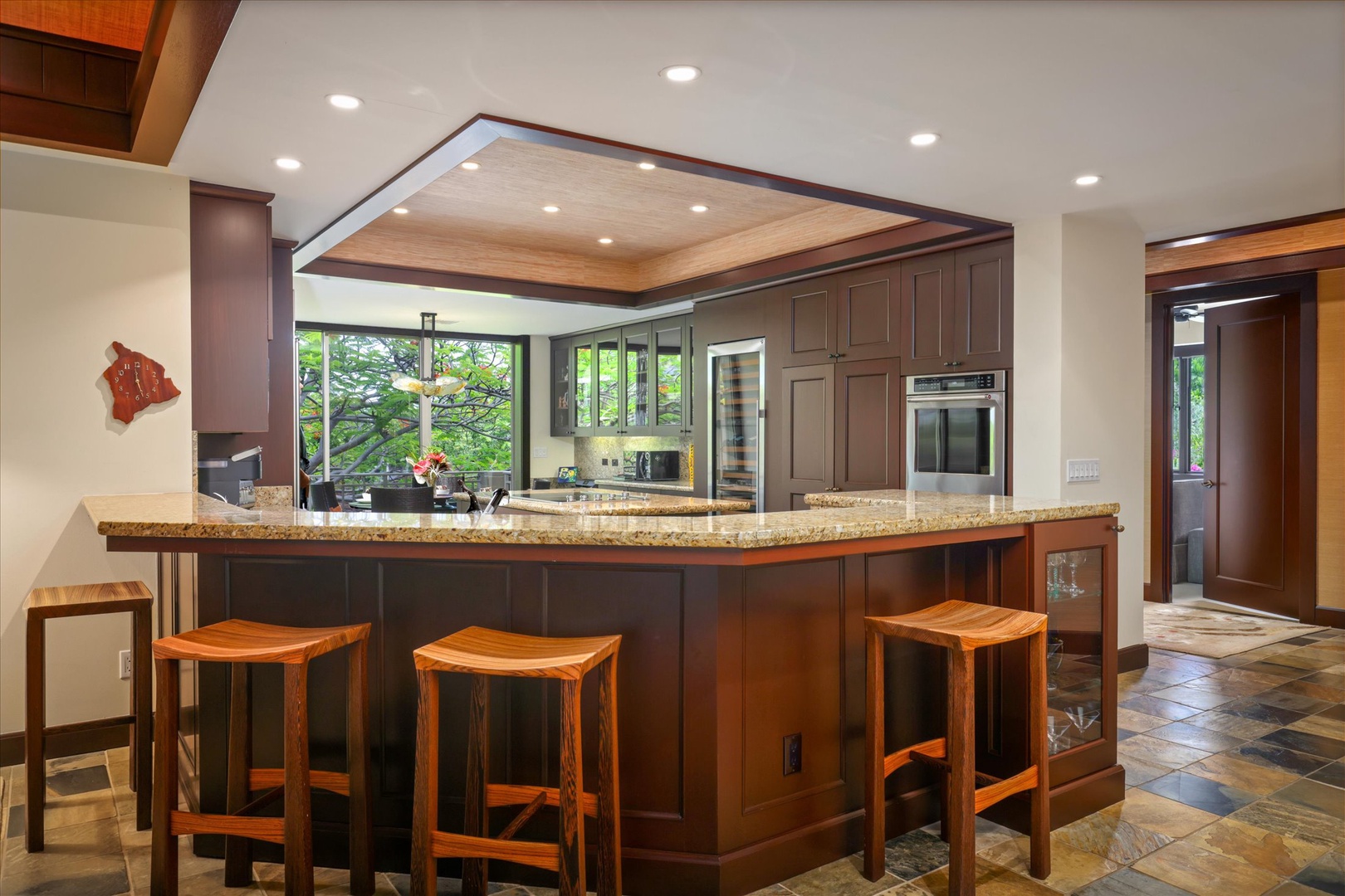 Kailua Kona Vacation Rentals, Wai'ulu Villa 115D - Gourmet kitchen with bar seating, open to lush views and fully equipped for chef-crafted meals or quick bites.