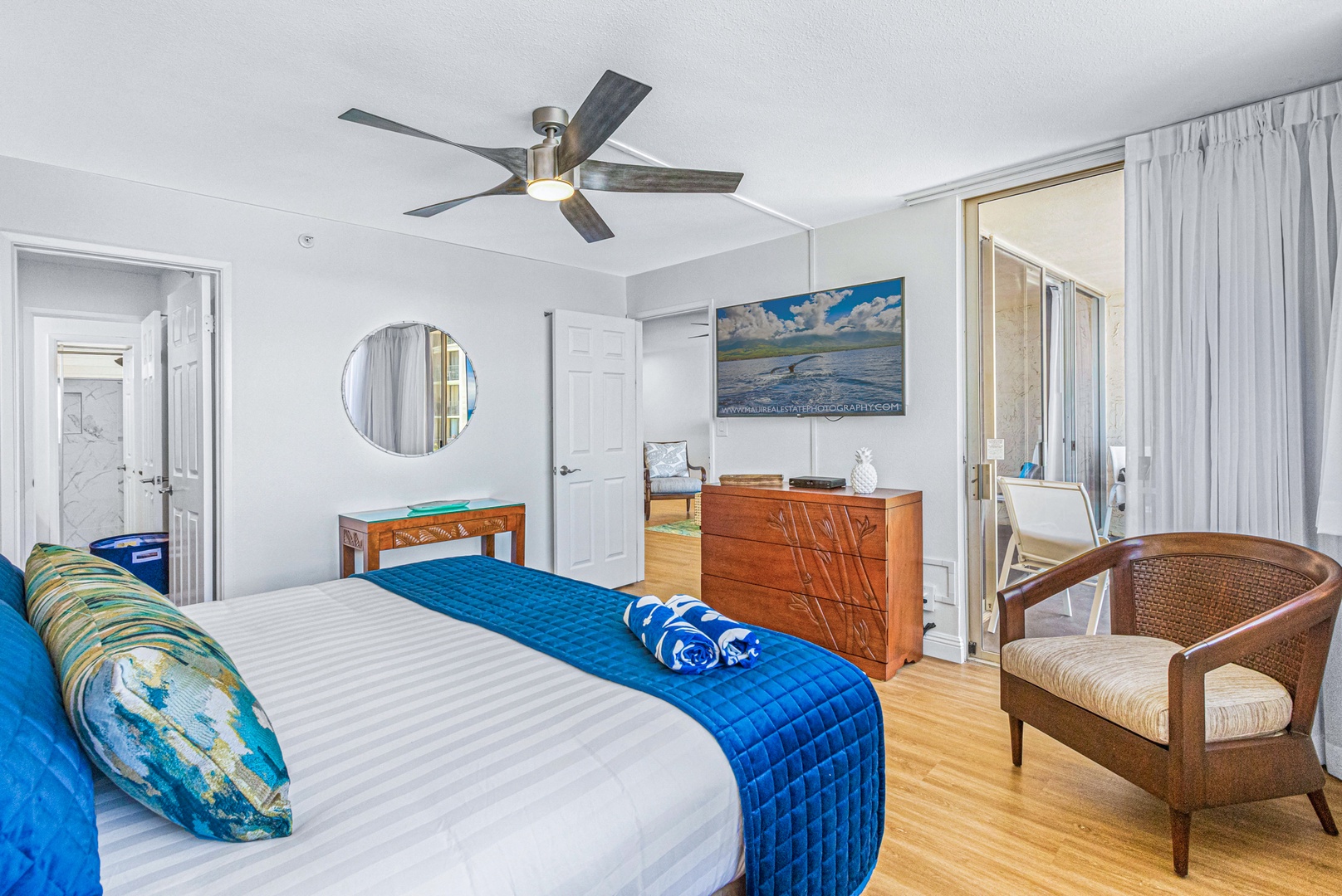 Lahaina Vacation Rentals, Royal Kahana 213 - Relax in the primary bedroom at Royal Kahana 213 with a TV, lounge chair, and lanai access with stunning views.
