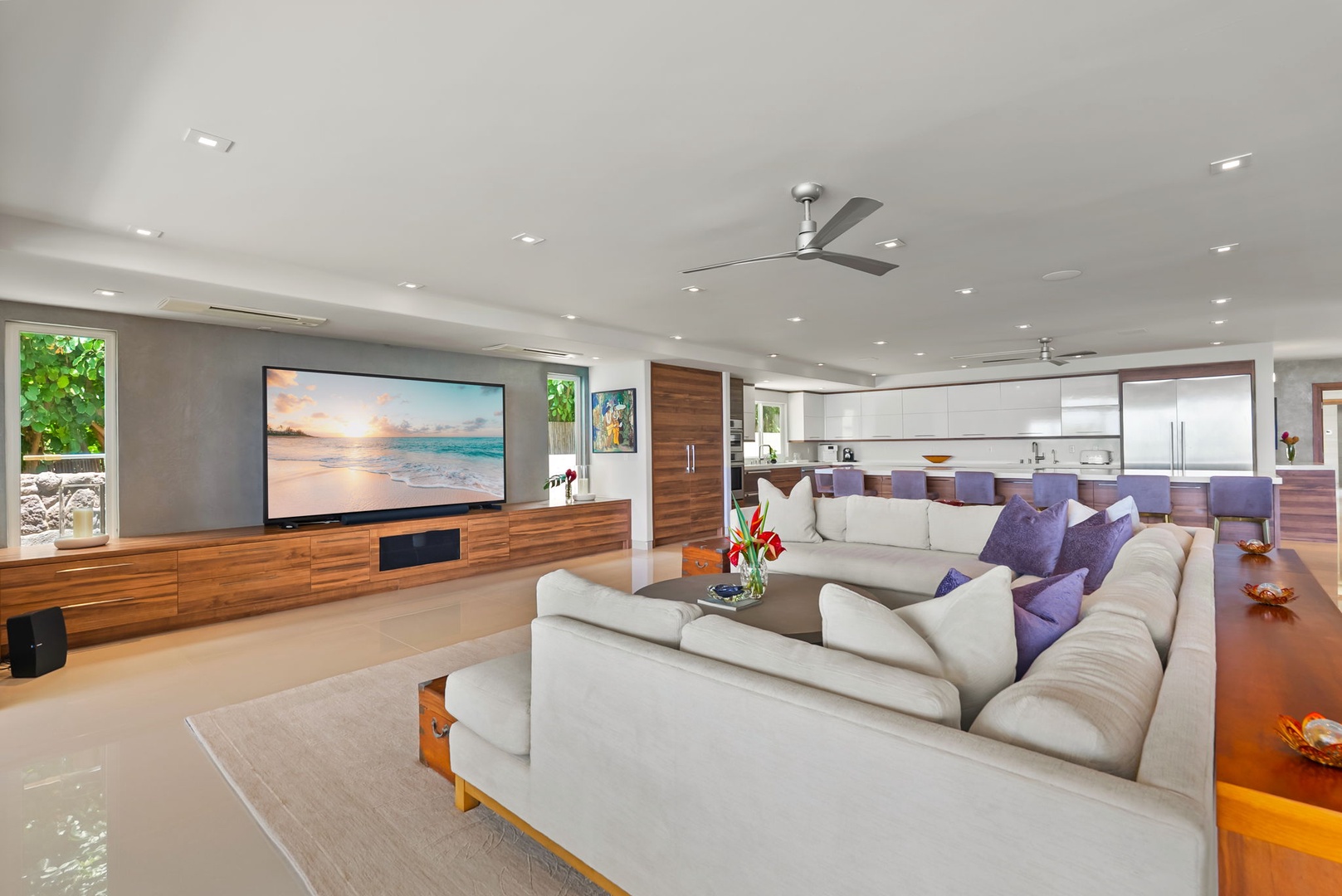 Honolulu Vacation Rentals, Diamond Head Beachfront Estate - Sink into plush seating in your open-concept living space, where modern design meets ocean-inspired comfort. Large windows frame natural light throughout this elegant retreat.