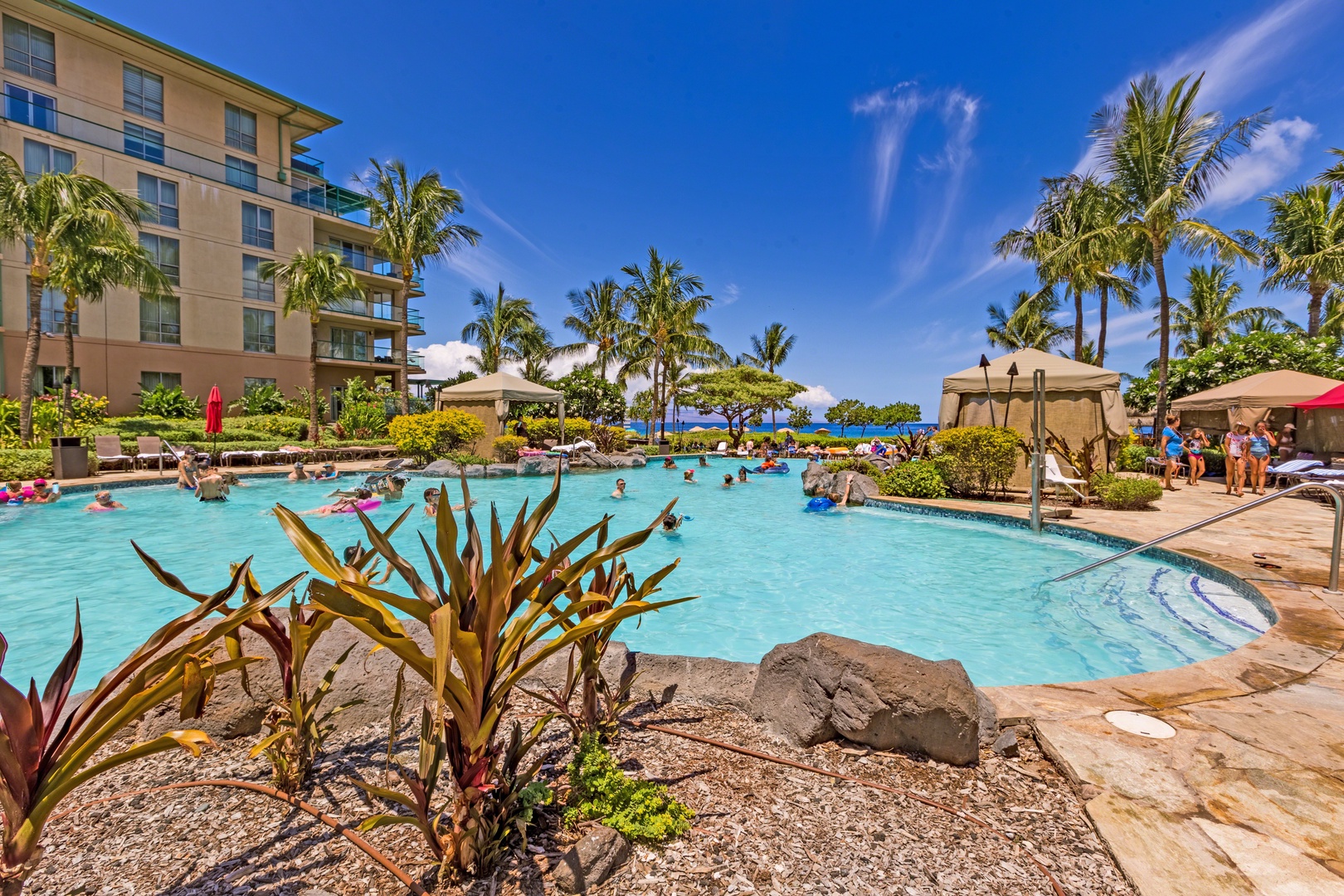 Lahaina Vacation Rentals, Honua Kai Hokulani 214 - Dive into the crystal-clear waters of the resort's expansive pool, surrounded by lush tropical landscaping and cozy cabanas.