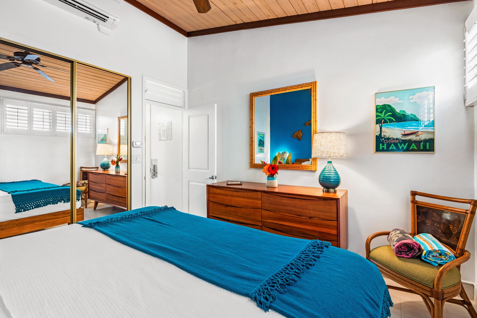 Lahaina Vacation Rentals, Napili Shores F-252 - A cozy bedroom with wooden accents, a bright blue throw, and stylish decor, offering a comfortable retreat.