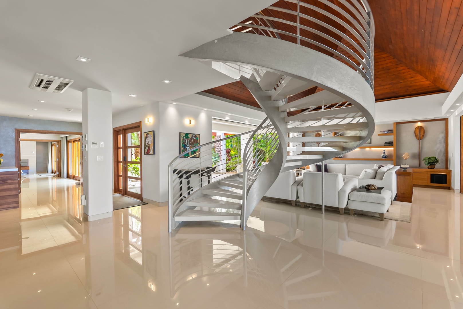 Honolulu Vacation Rentals, Diamond Head Beachfront Estate - Step into a beautifully designed open-concept space where modern elegance meets warm island-inspired touches. The dramatic spiral staircase and polished floors reflect natural light, creating an airy, welcoming vibe.