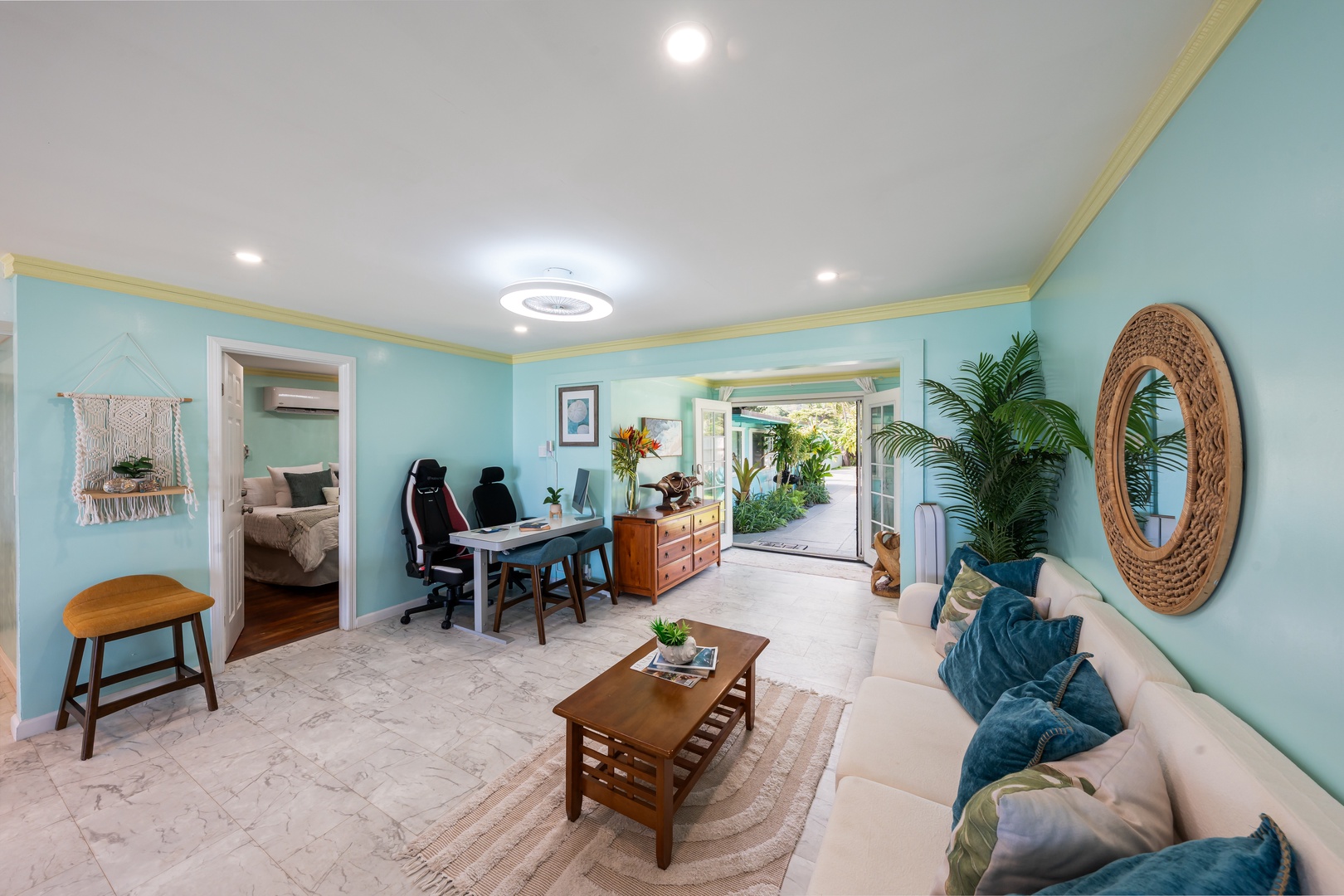 Hauula Vacation Rentals, Private Beach Paradise - Tropical-inspired living area with turquoise walls and a cozy space to unwind.