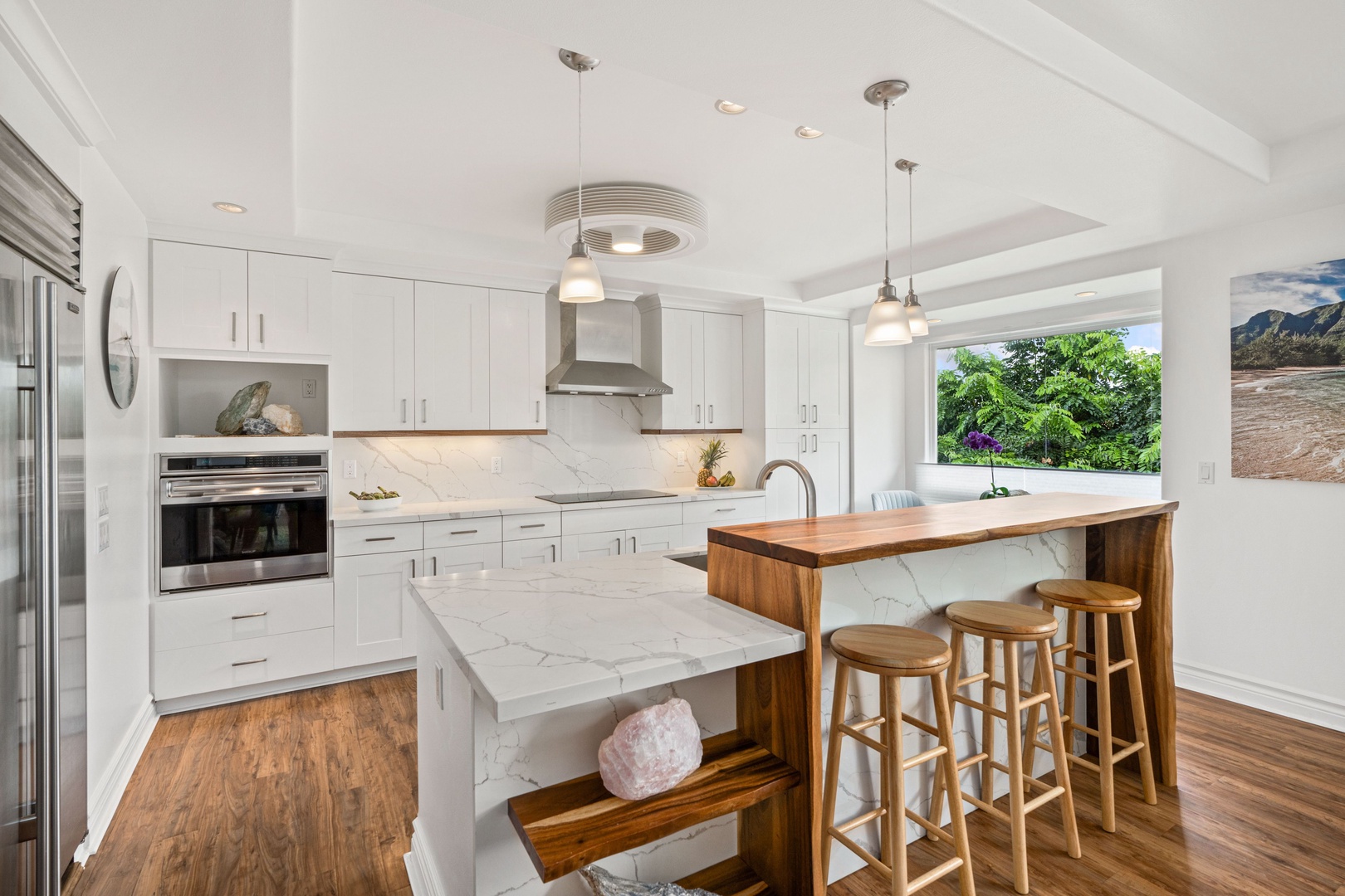 Princeville Vacation Rentals, Tropical Elegance - Modern kitchen with bar seating, ideal for vacation breakfasts and gatherings.