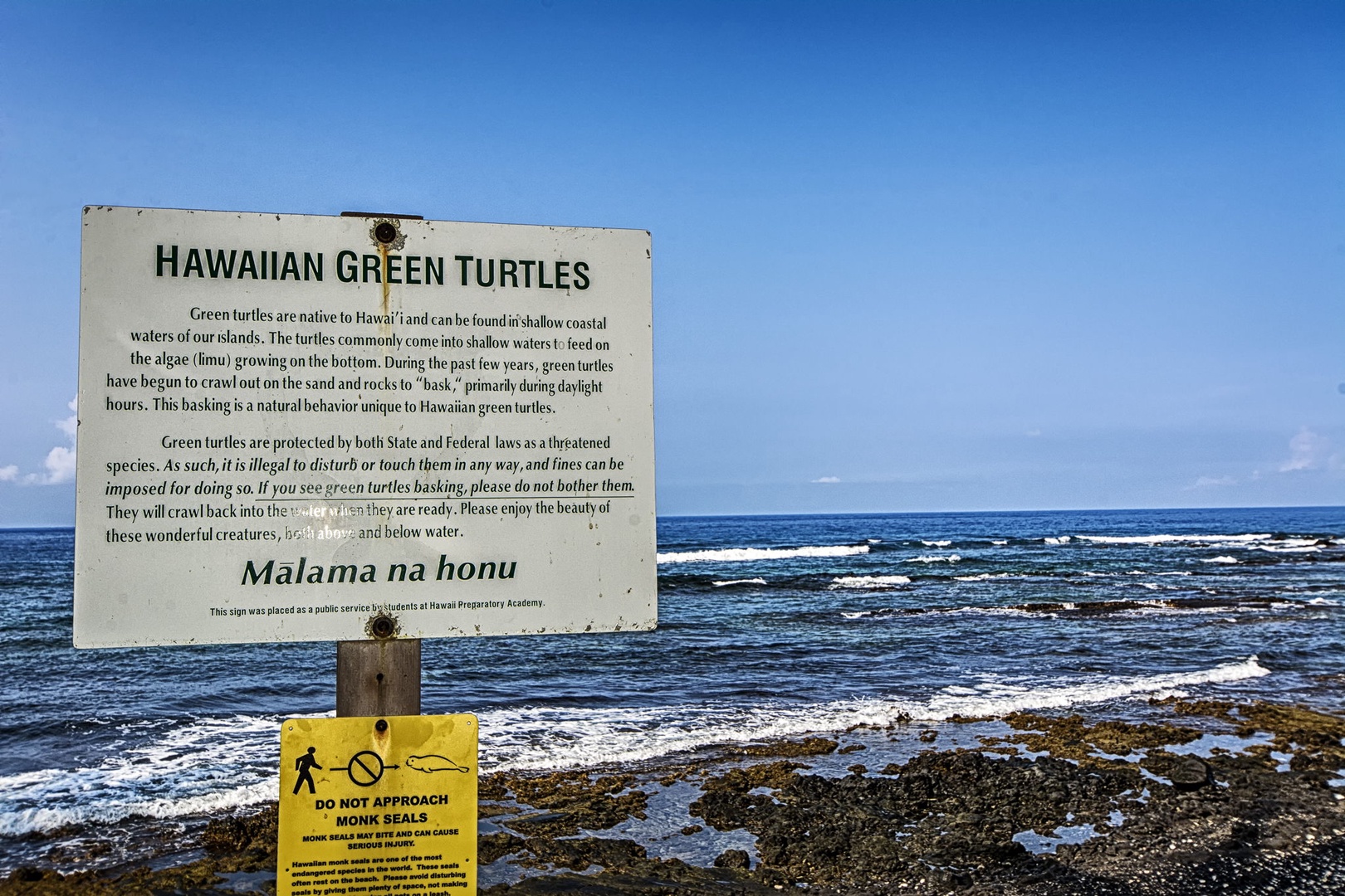 Kailua Kona Vacation Rentals, Keauhou Kona Surf & Racquet 1104 - A posted sign marks the rugged lava shoreline, rocky coast rather than a swim beach.