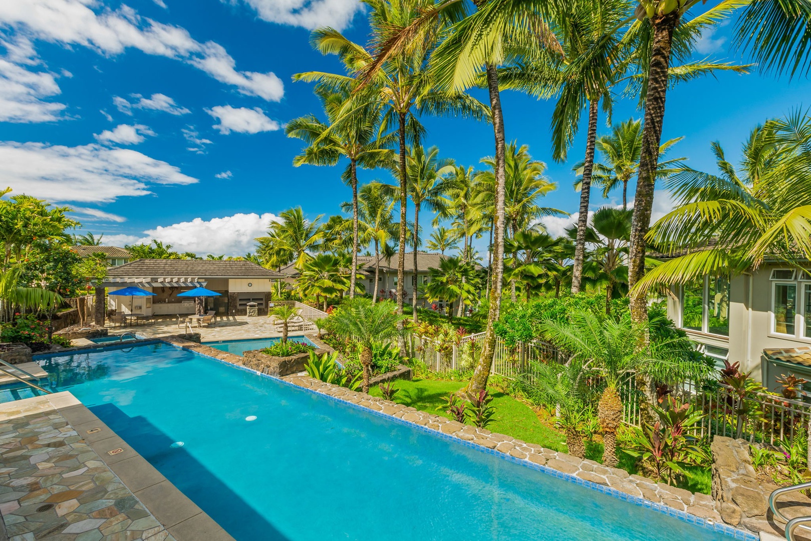 Princeville Vacation Rentals, Kaiulani #8 - Swim laps the length of a long, narrow pool edged in palms and flowers.