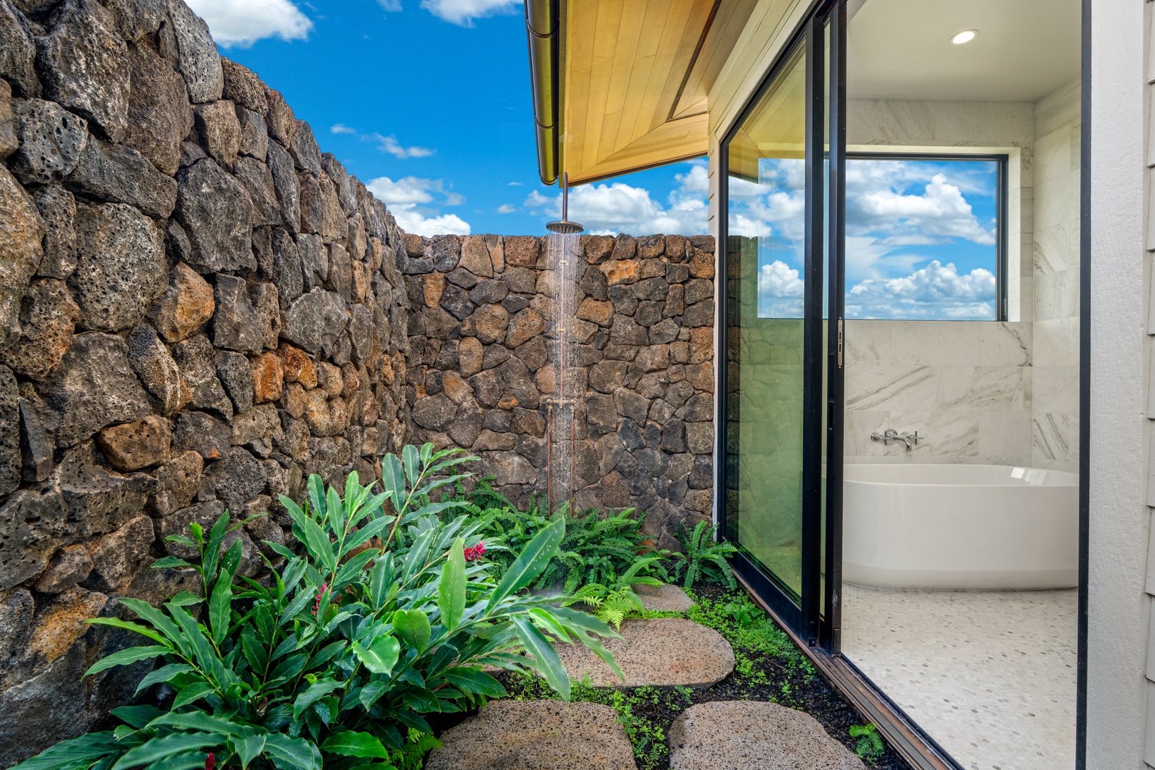 Koloa Vacation Rentals, Hale Laule'a at Kukui'ula - Escape to your private outdoor shower surrounded by lush tropical plants and volcanic stone walls under the open sky.